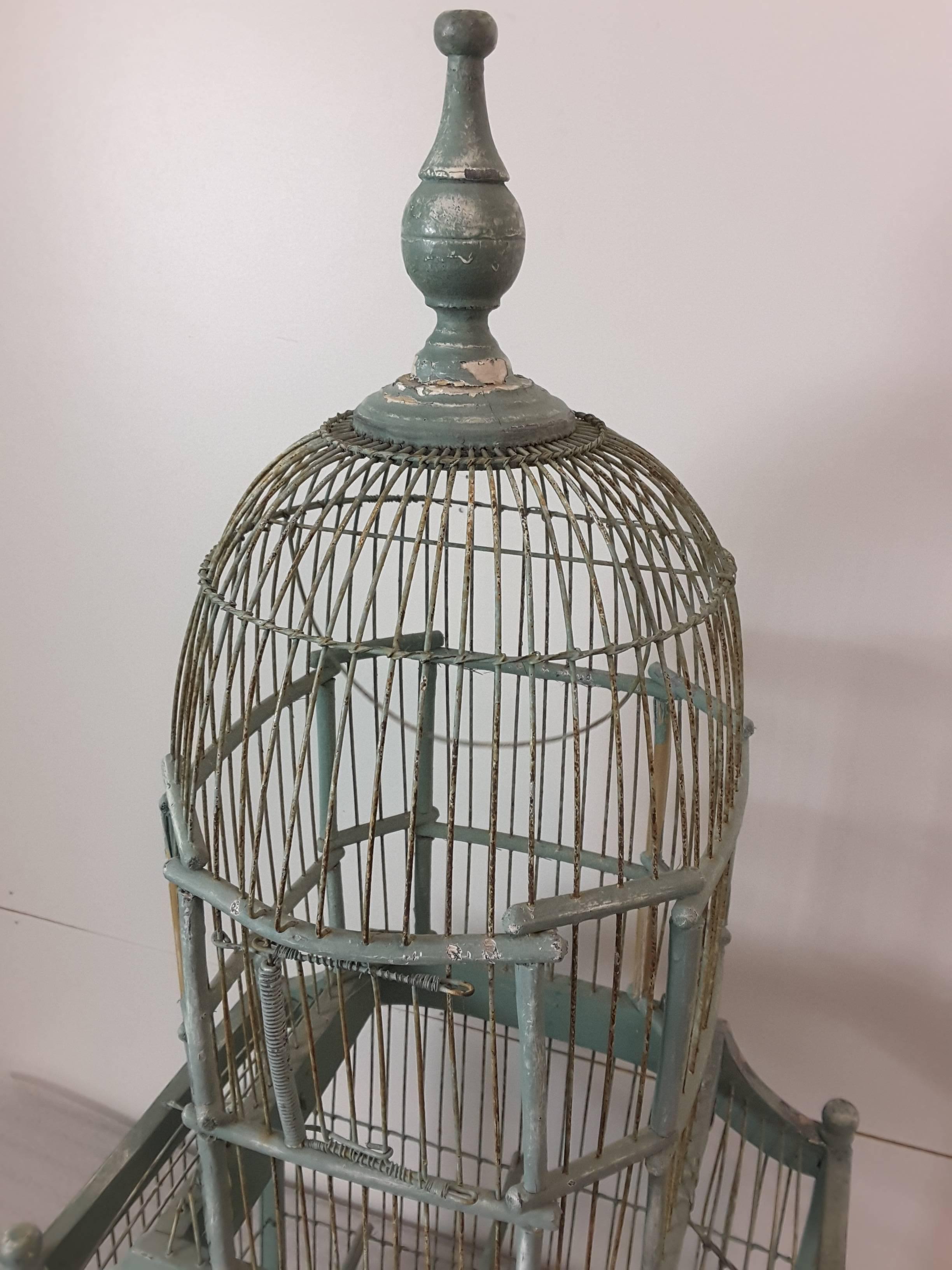 A Victorian Cathedral dome bird cage in original green paint, Circa 1880, Upper and lower spring loaded doors, Wire swing in the upper dome and two perch bars on the lower section. The bottom has a flip door to remove the original cleaning tray. The