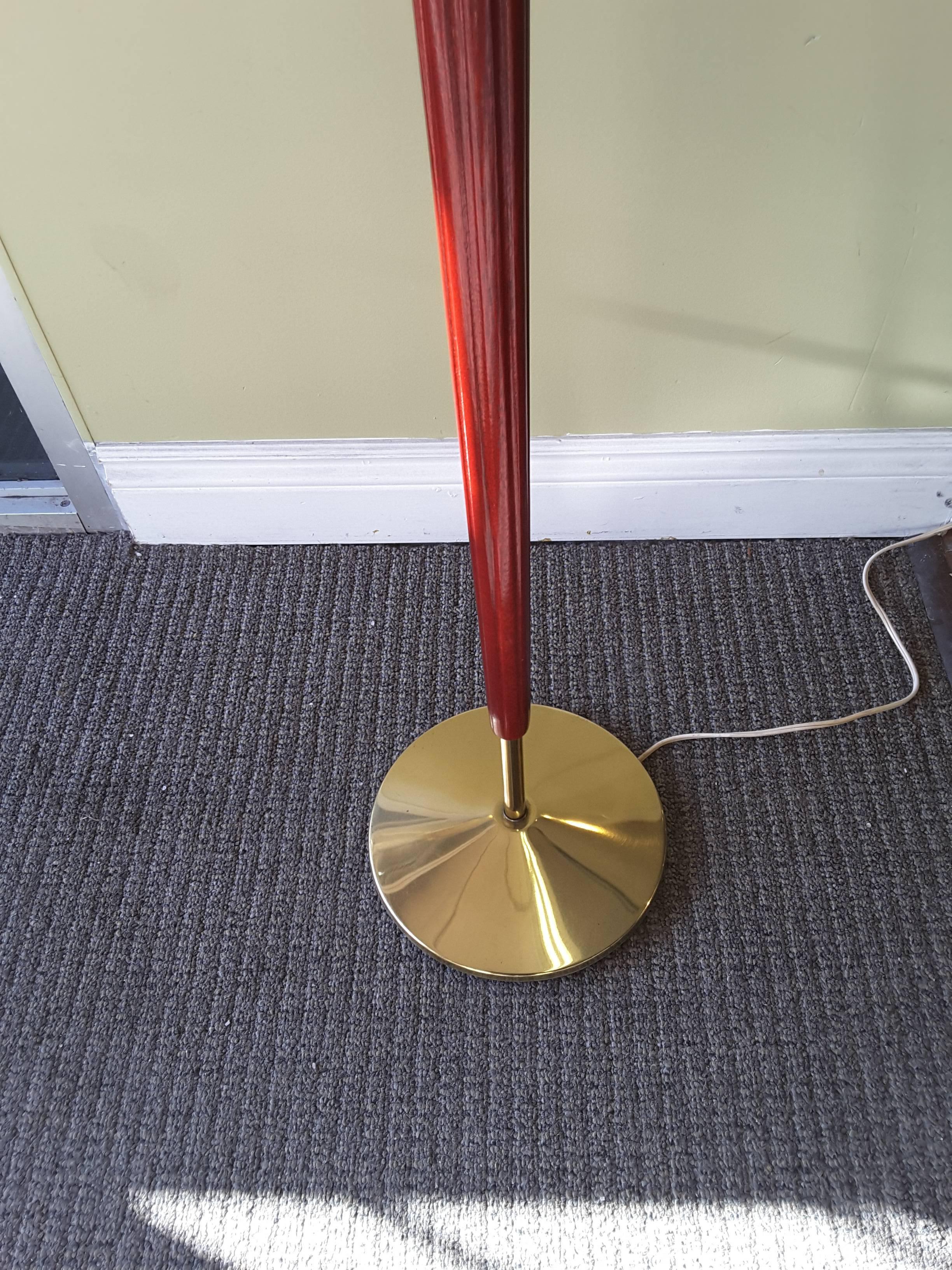 Mid-Century brass and mahogany Classic style floor lamp, the lamp has a fluted tapered column to a raised brass disc above a mahogany base. Tri-light socket and a milk glass shade and comes with cloth shade which has accented brass colored edging,