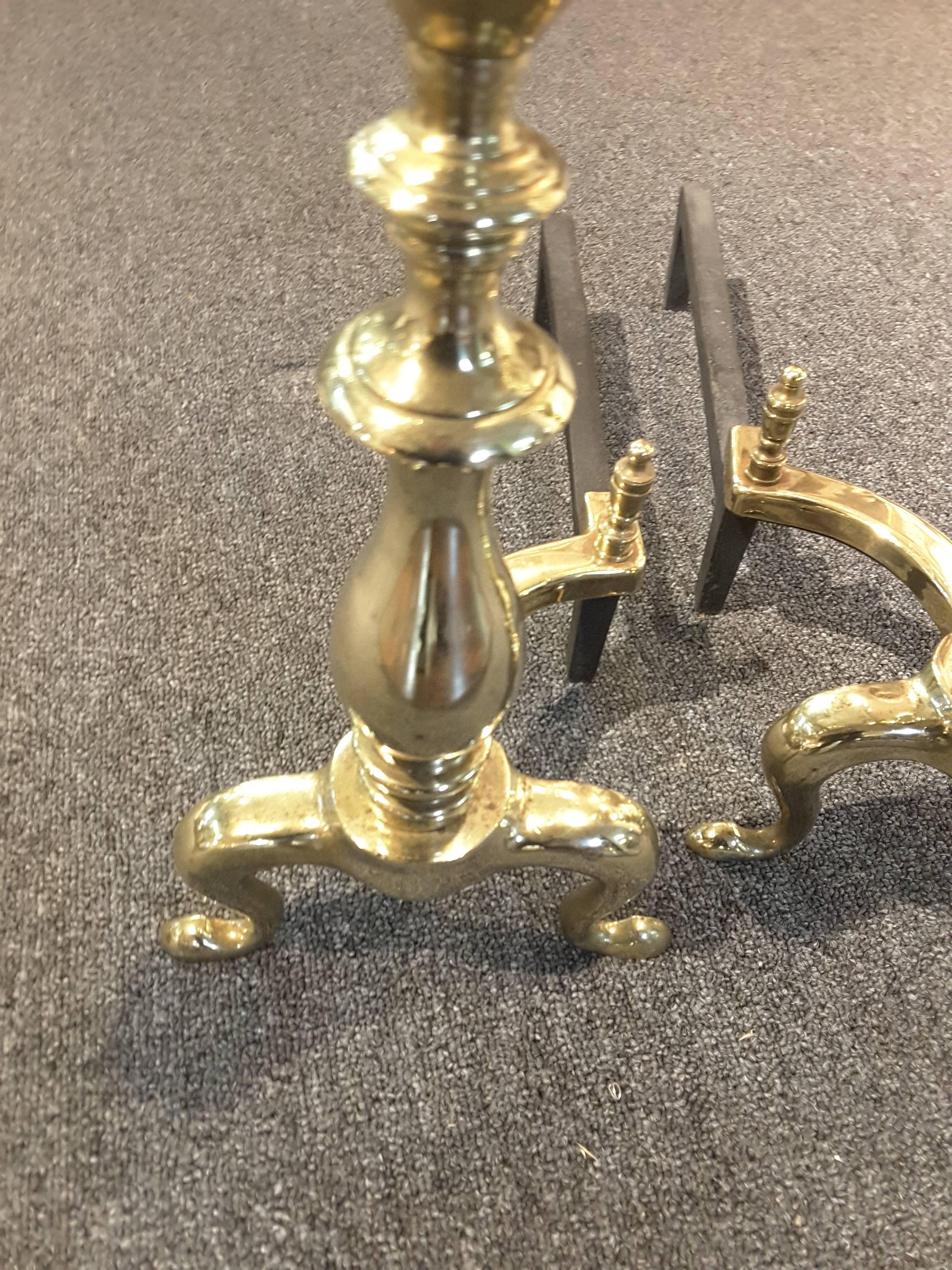 Pair of late 19th century solid brass andirons with log stops on a cabriole leg to a pad foot. Cast Iron back inserts. The andirons measure 21