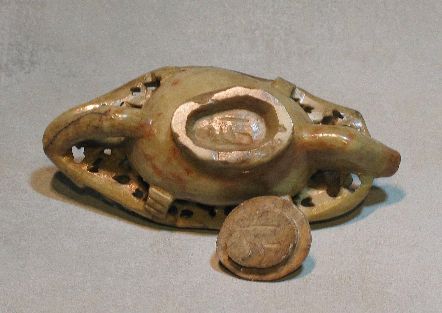 A carved Chinese soapstone water dropper, boat shaped receptacle with spout and handle, carved with trailing floral stems and a domed cover with a bird forming a finial. Late Qing/Republic period. The water dropper measures 6