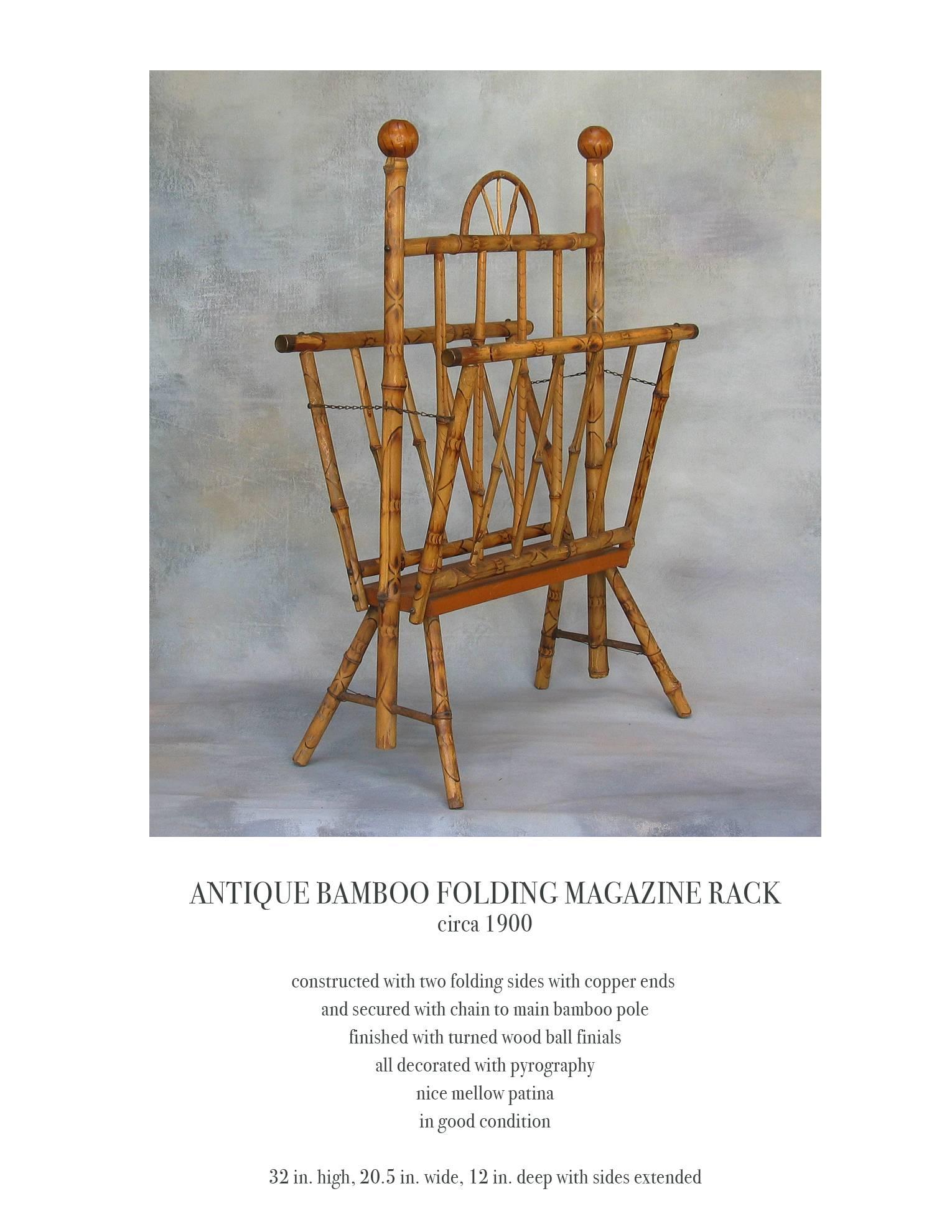 Antique American bamboo folding magazine rack circa 1900, constructed with two folding sides with copper ends and secured with a chain to main bamboo pole. Finished with turned wood ball finials, all decorated with pyrography, nice mellow patina and