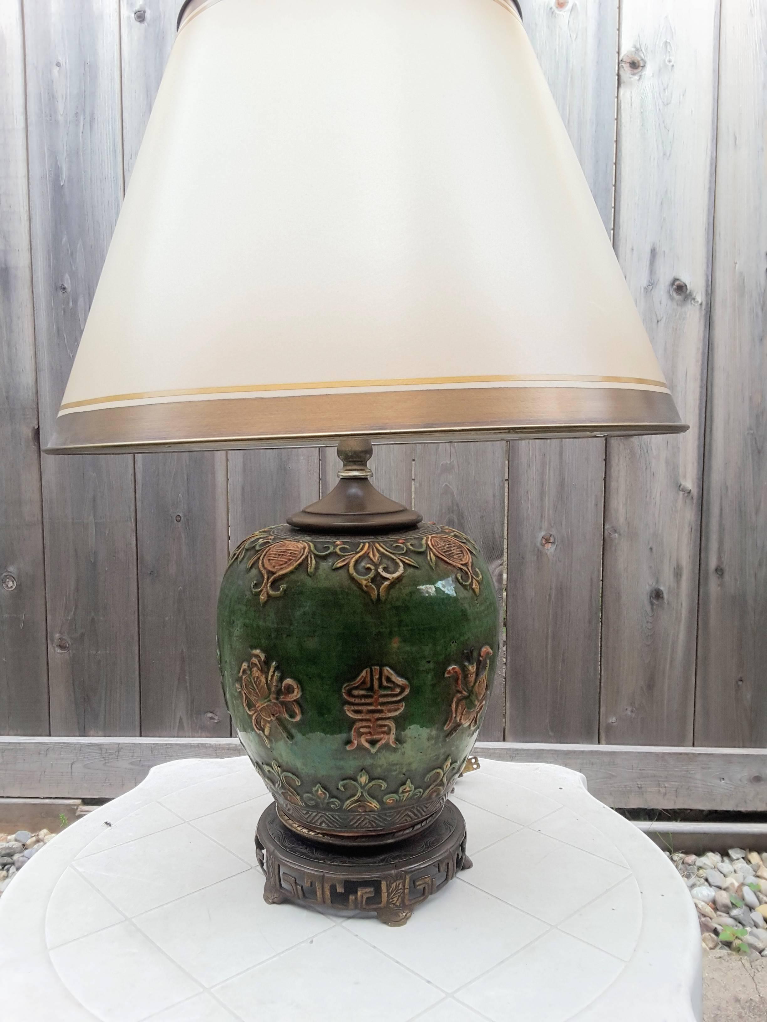 Chinese ginger jar Mid-Century table lamp, the lamp has a bronze patinated base with scroll work to a green colored ginger jar body with scrolls and medallions in a rust brown highlights. The jar has a bronze colored cap to match the base. The lamp