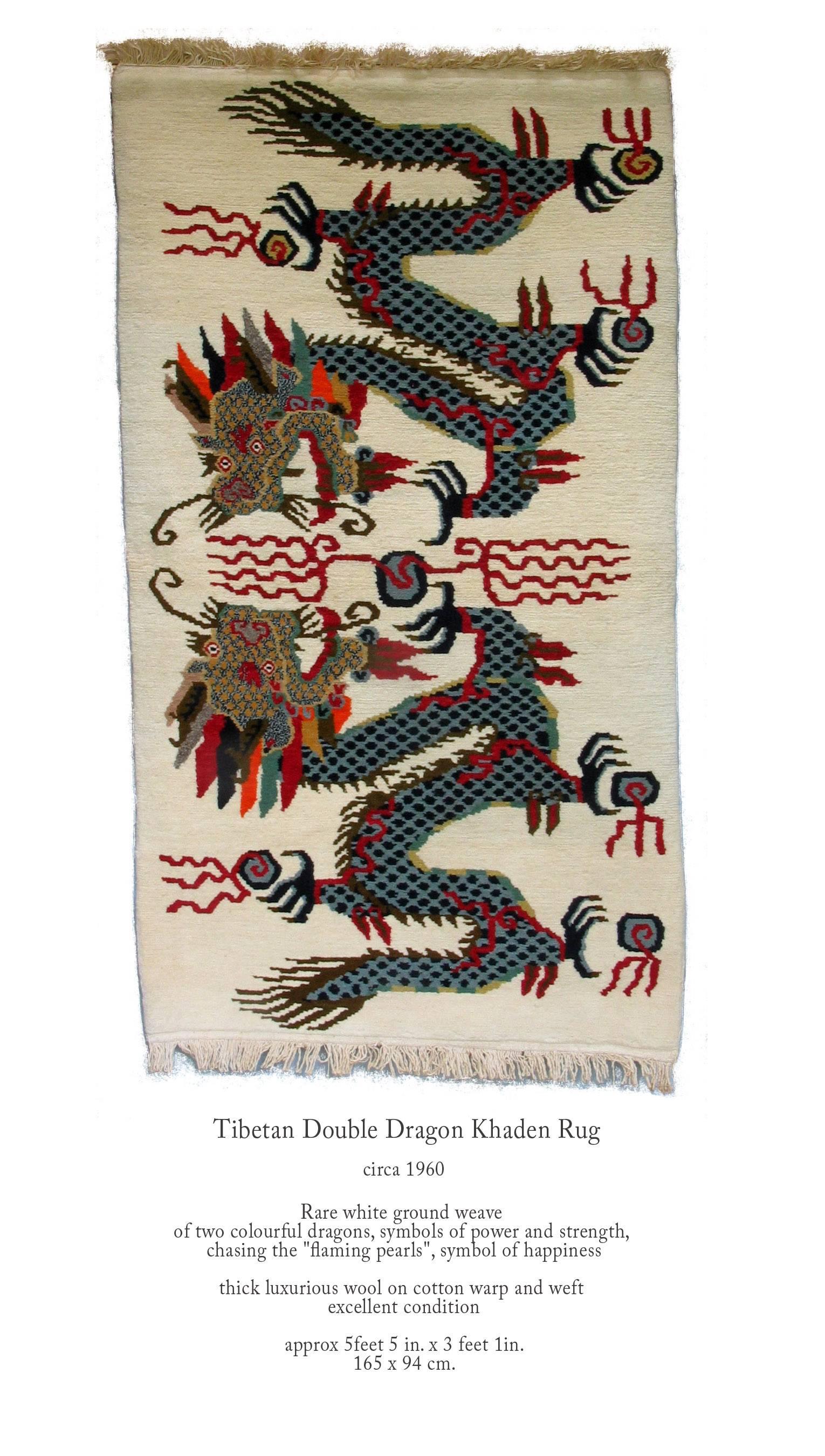 Tibetan double dragon Khaden rug, circa 1960, rare white ground weave of two colorful dragons, symbols of power and strength, they are chasing the 