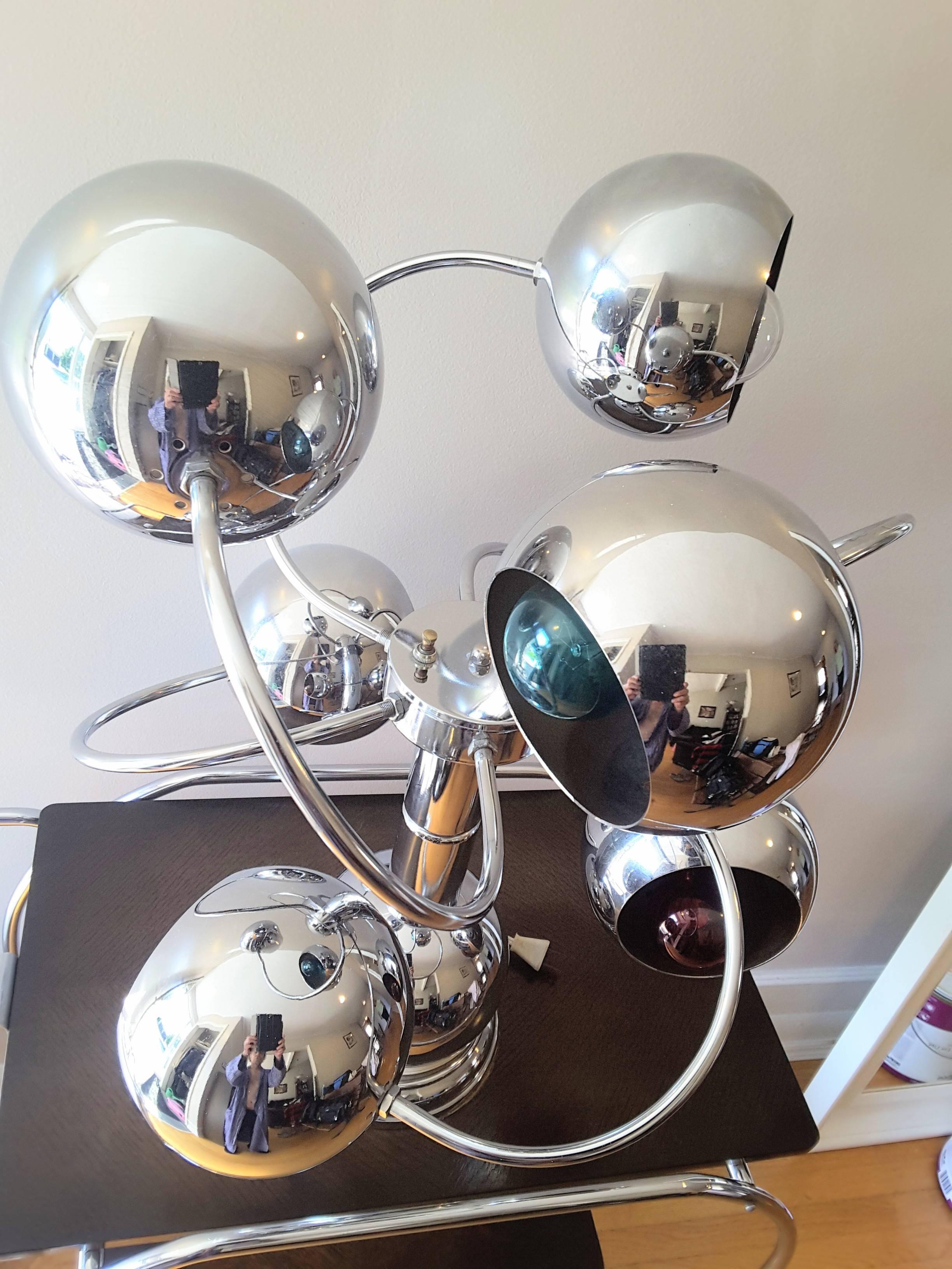 Atomic chrome six-arm table lamp, Mid-Century, late 1960s-early 1970s, chrome metal body, with six lights are in a clockwise circular pattern in a an eye ball style mount. The lamp measures 25