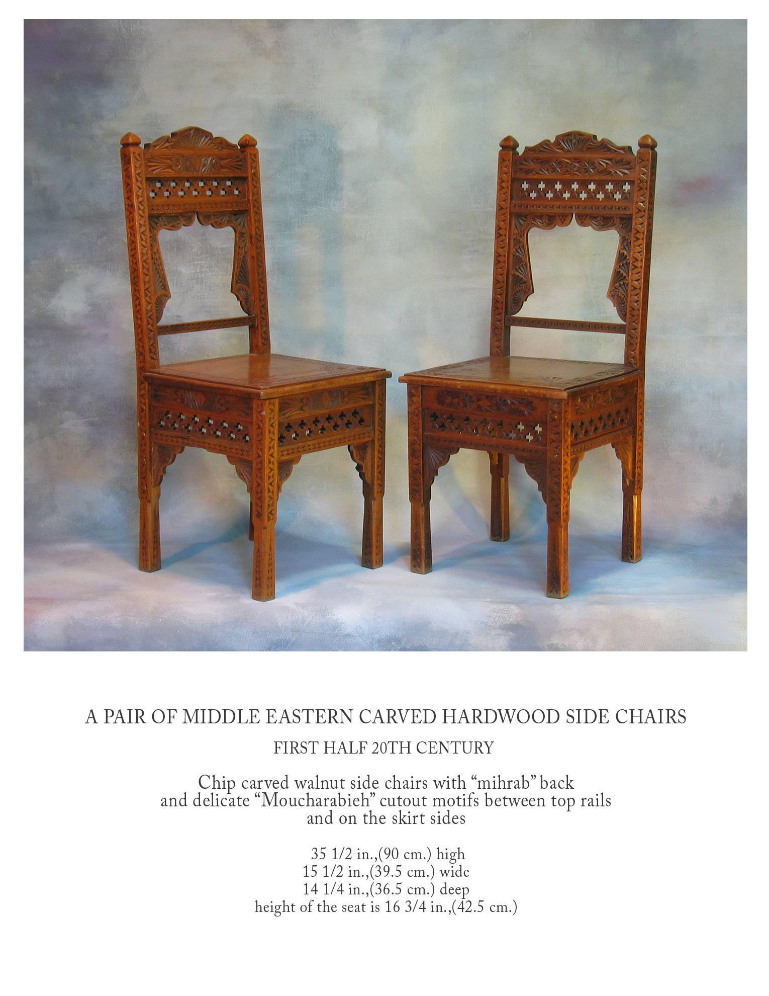 A pair of middle eastern carved hardwood side chairs, first half of the 20th century, chip carved walnut side chairs with 