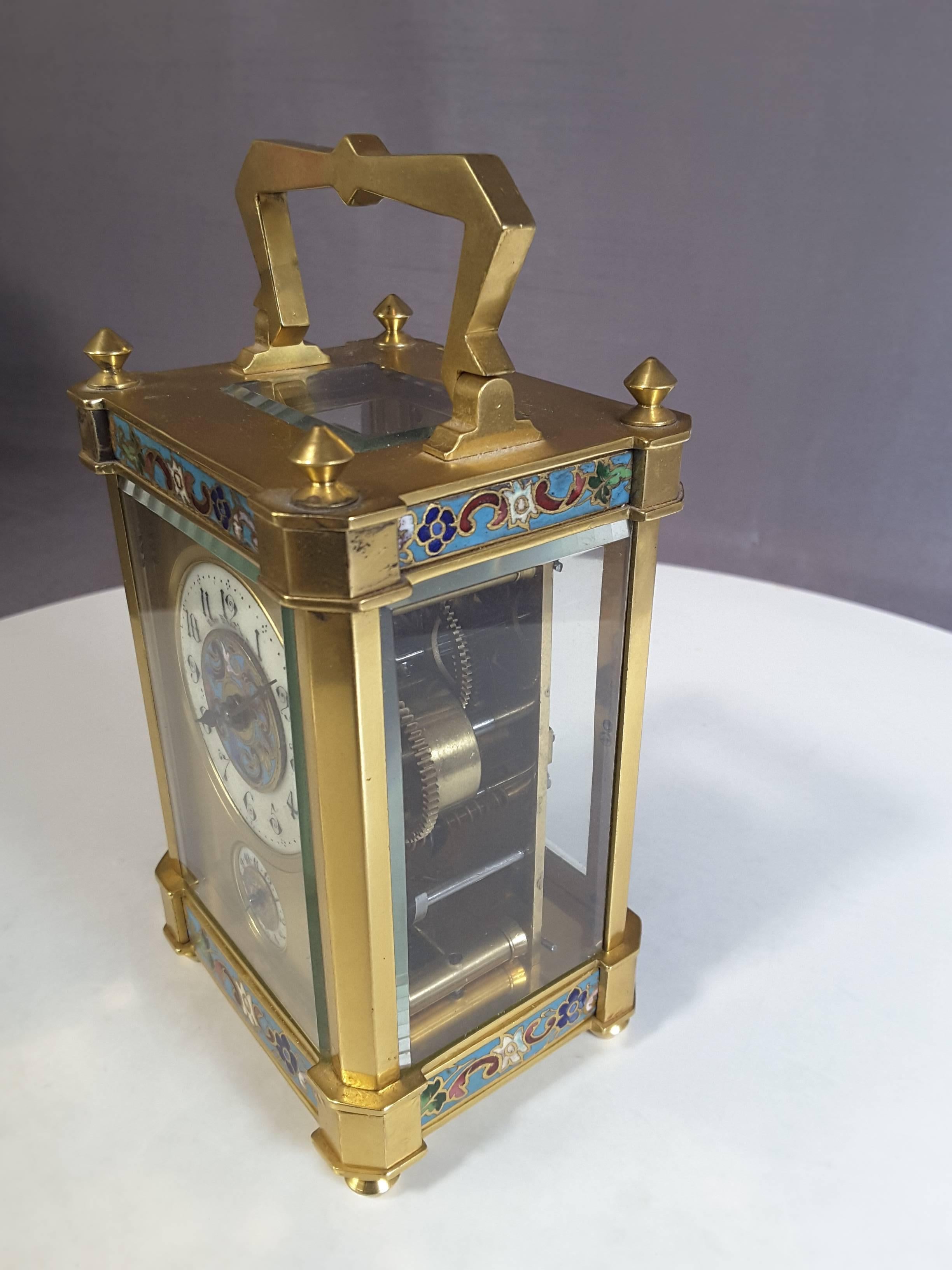 French carriage clock with champlevé decoration, gilt brass case, eight day movement with alarm, in pristine working condition, time and alarm, upper and lower dials in the original travel case, with key, clear glass display and exterior cover,