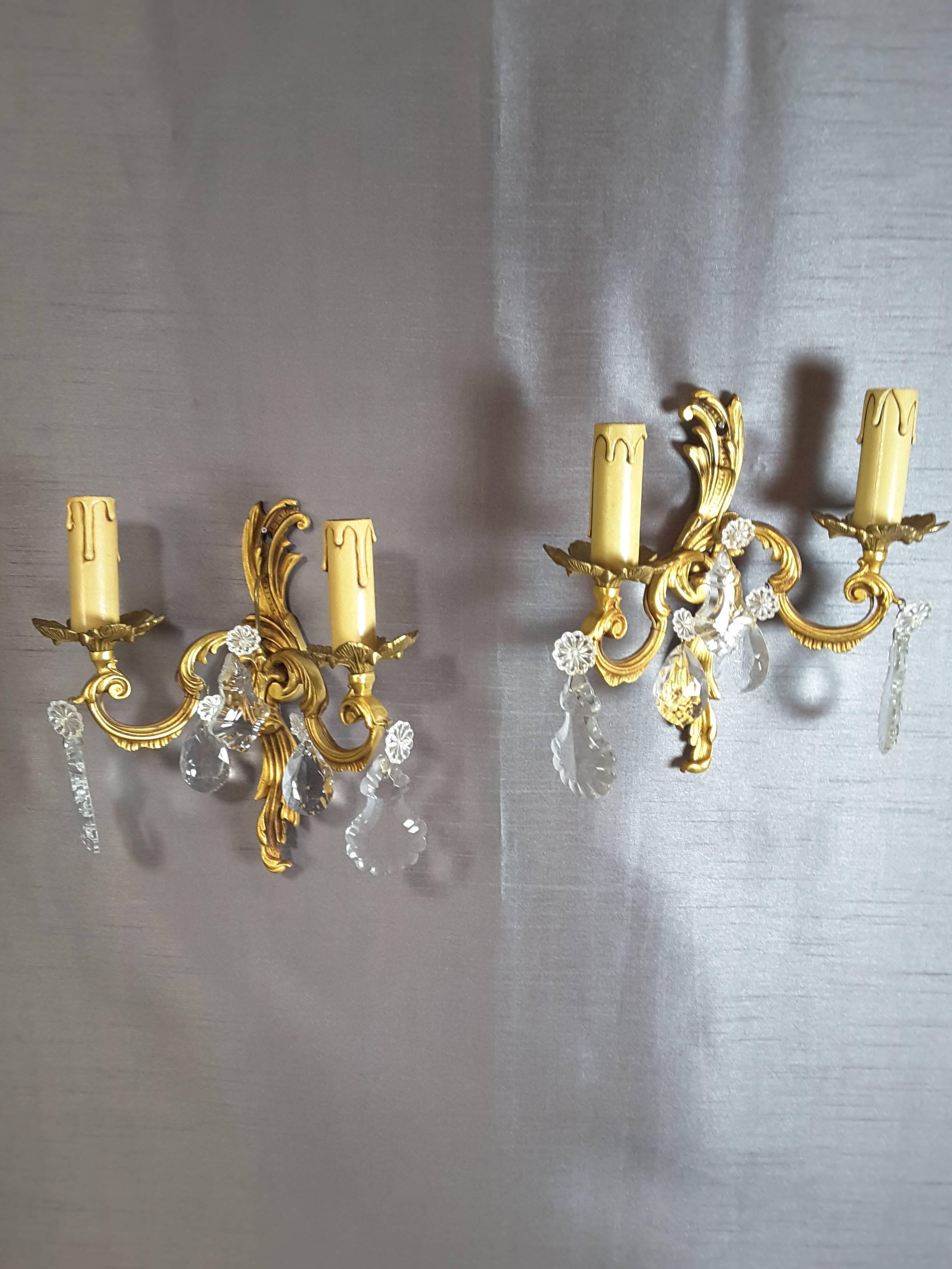 Pair of brass/gilt wall sconces with floral crystals, the sconces are done in a foliate style with an 