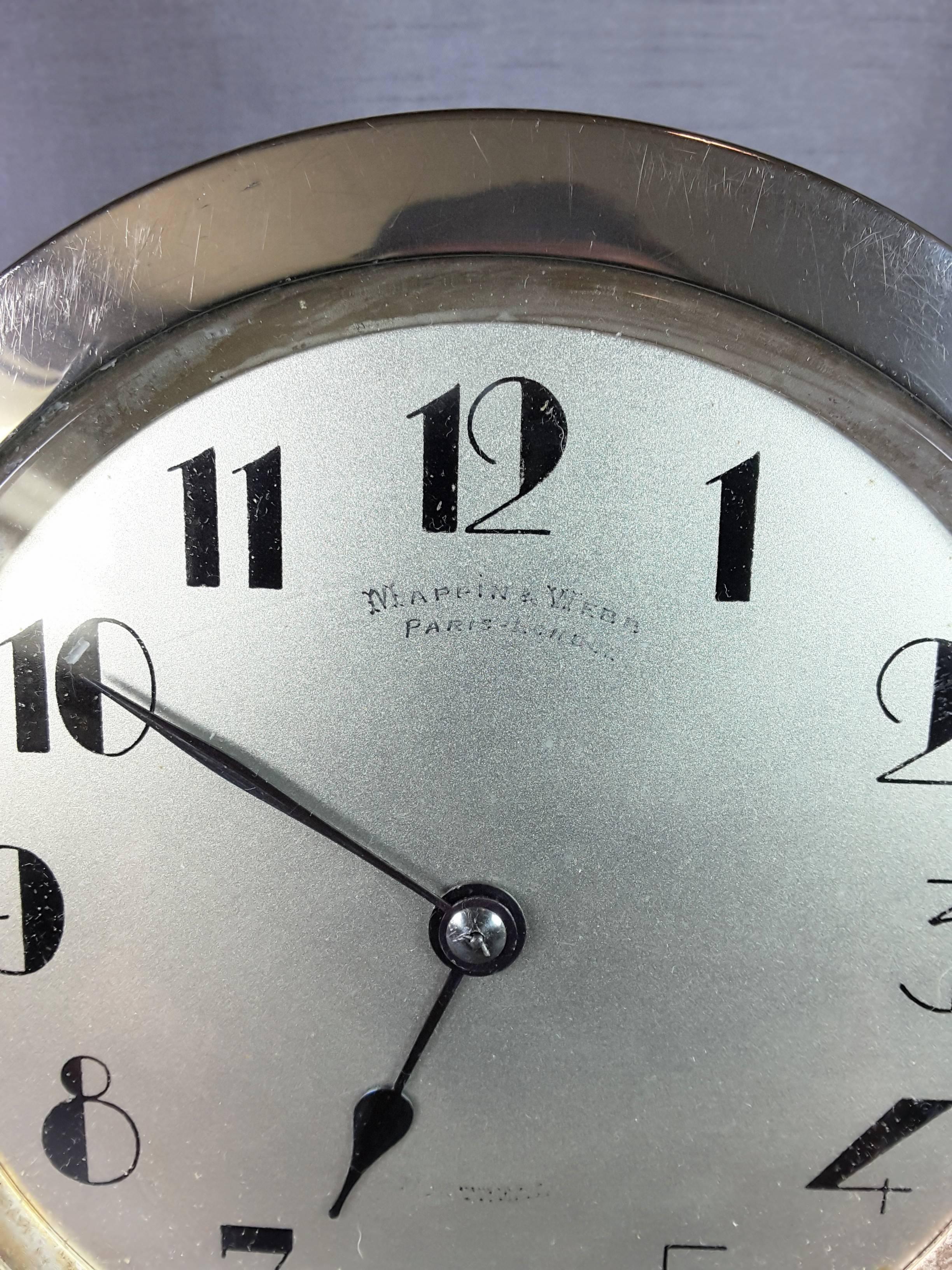 An Art Deco Mappin & Webb Paris-London large circular desk clock, with a painted black number dial on a silvered face, marked Mappin & Webb Paris-London under the 12 and under the 6 it is marked Made in France, the face and name is showing wear on