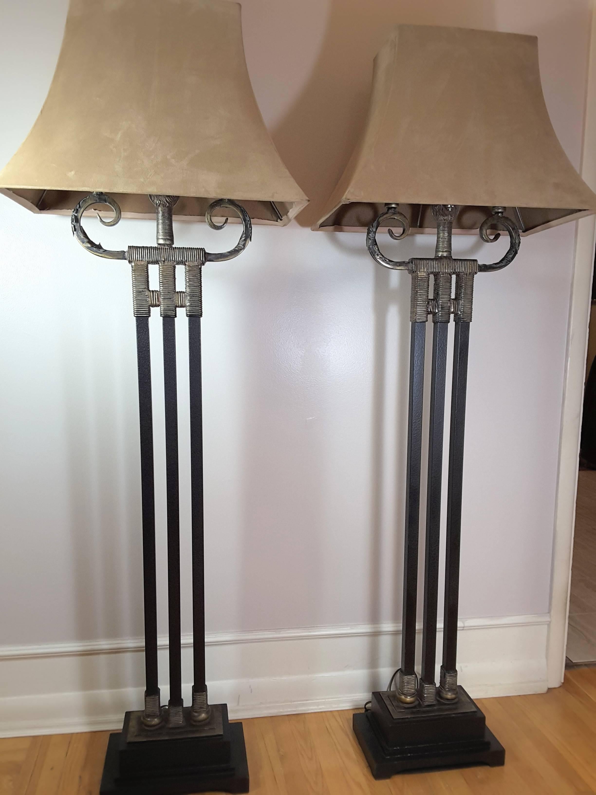 A majestic lions head Mid-Century Modern pair of floor lamps, three black alligator finish columns, scrolled top with a double sided lions head in the centre, on a plinth base. The lamps have new sockets and wiring. The columns are wire wrapped on