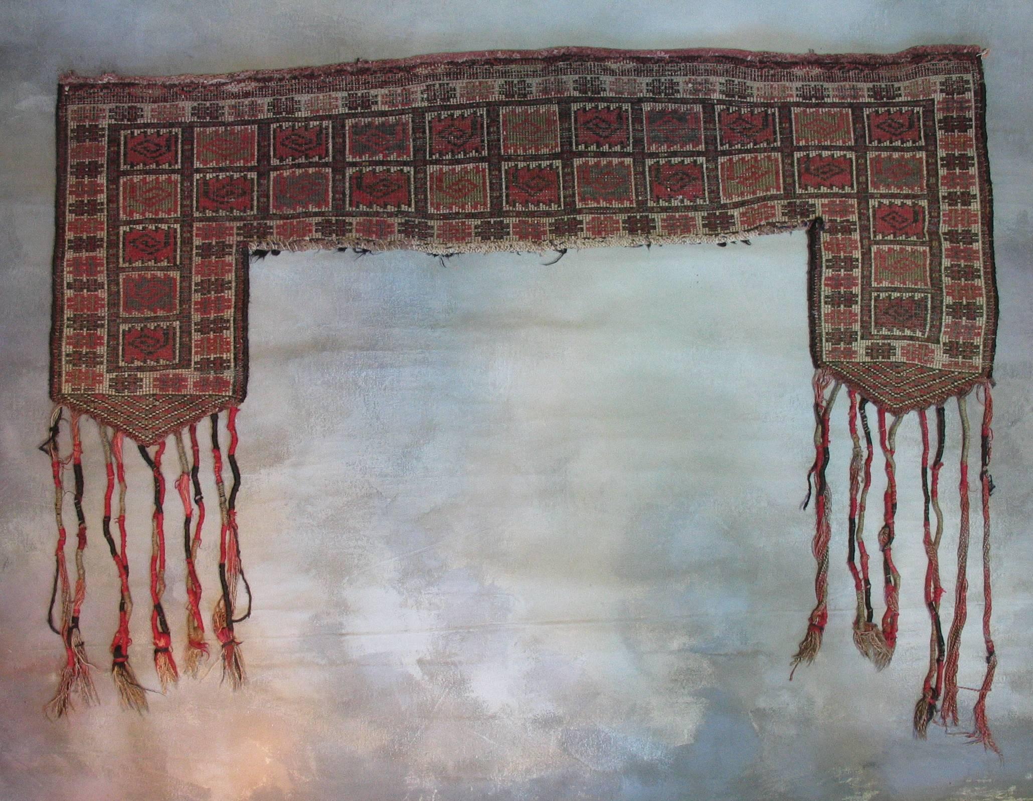 Tapis en laine Ersari Kapunuk du Turkménistan ou décoration de porte d'entrée, deuxième moitié du 19e siècle, poil de laine, chaîne de laine et trame de laine, de couleur rouge et terre, avec de longs glands décoratifs. Il est utilisé pour la