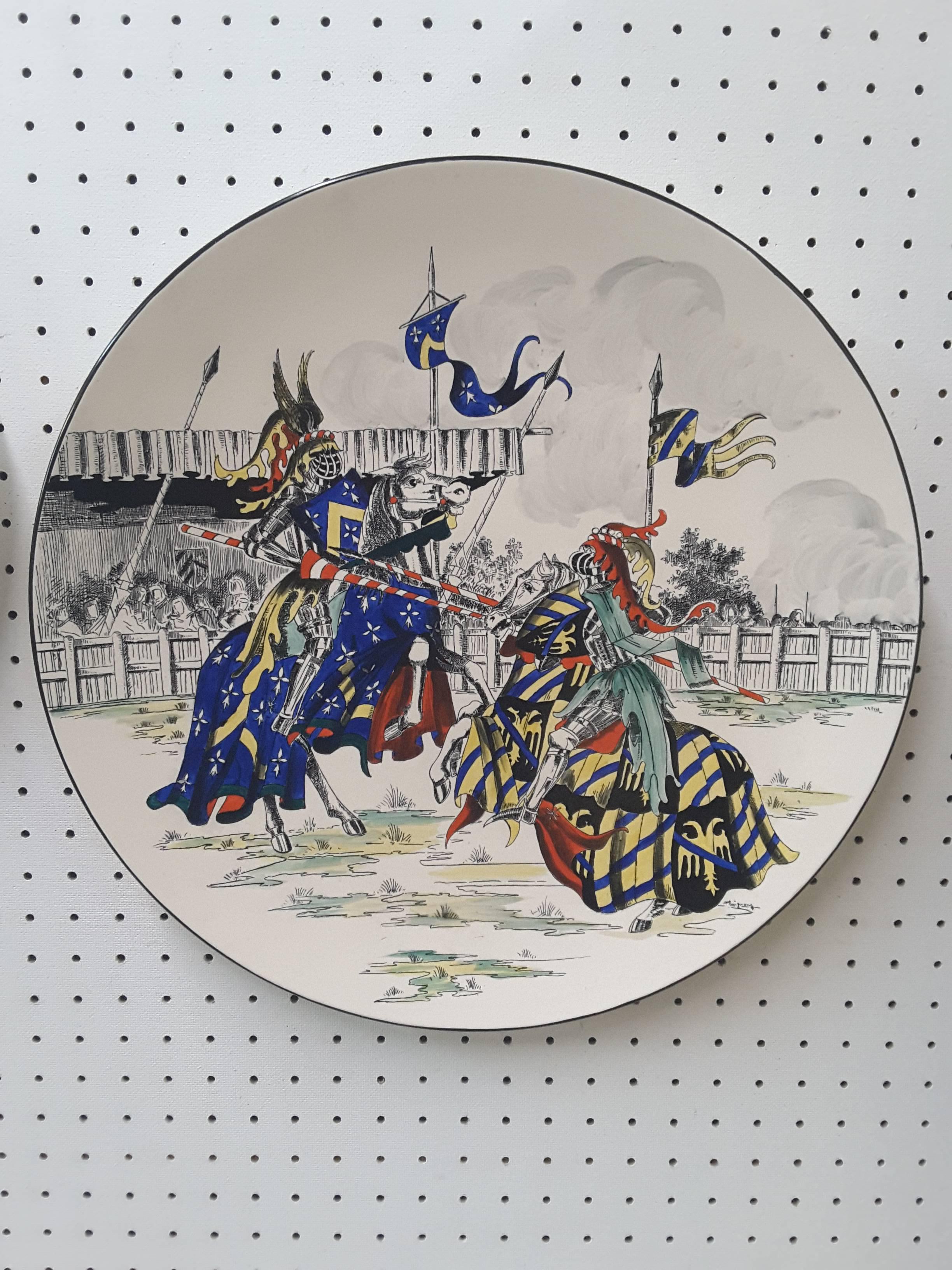Pair of large longwy medival scene painted, 1950s chargers, each charger has a medival jousting tournament scene, (typical of 1950s decor) The chargers measure 18