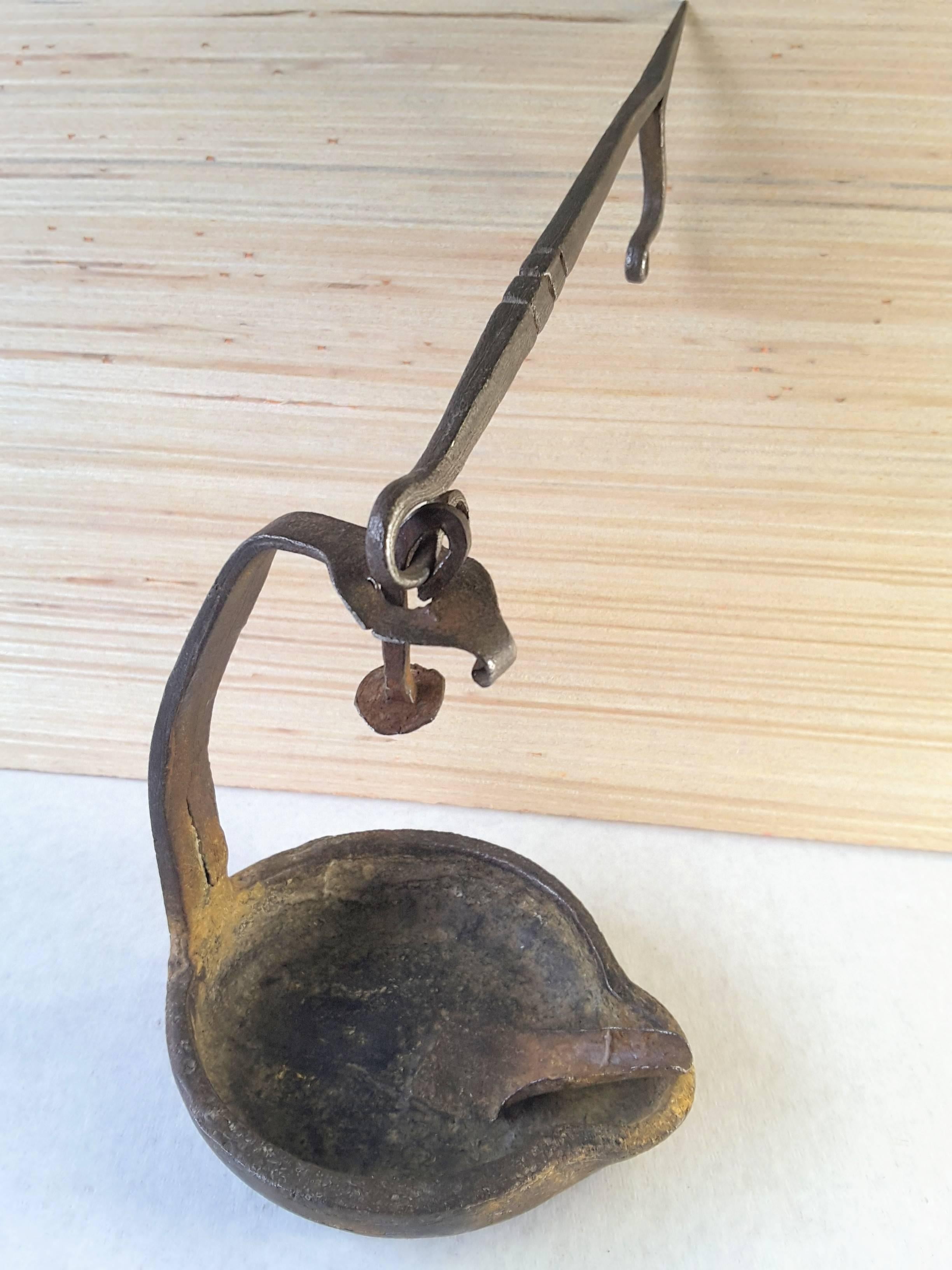 A late 18th-early 19th century swing post mount whale oil lamp, a fine example of a ships or wall/post mount whale oil lamp, which swings from the top as the spike is fixed to a post or wall to avoid spilling the oil from a rocking ship or by