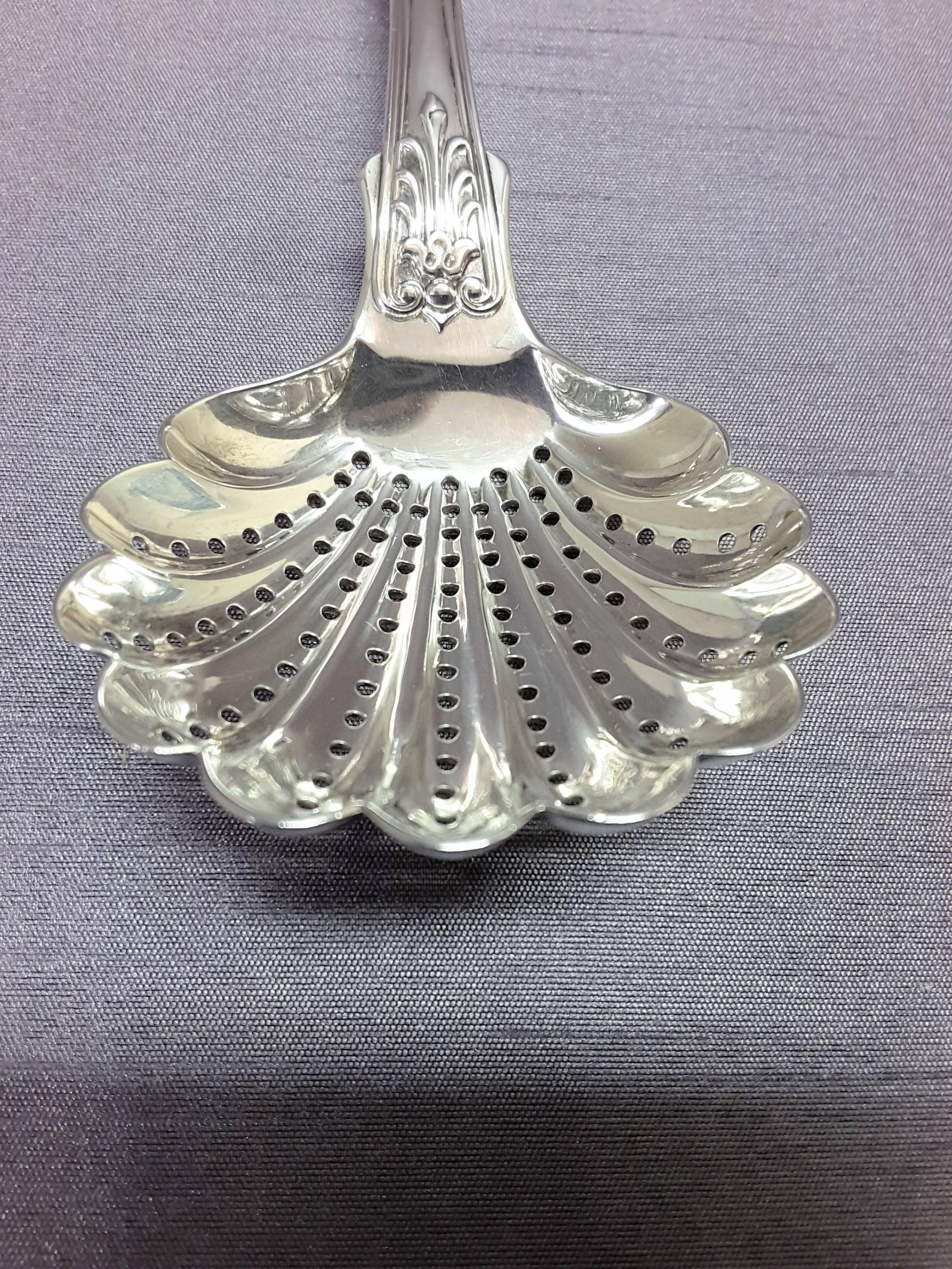 Georgian sterling silver ladle hallmarked for London, 1802, the ladle has a pierced shell shaped bowl for straining liquids, shaped handle, and a sitting crowned lion monogram on the top of the handle. The ladle measures 8 1/4