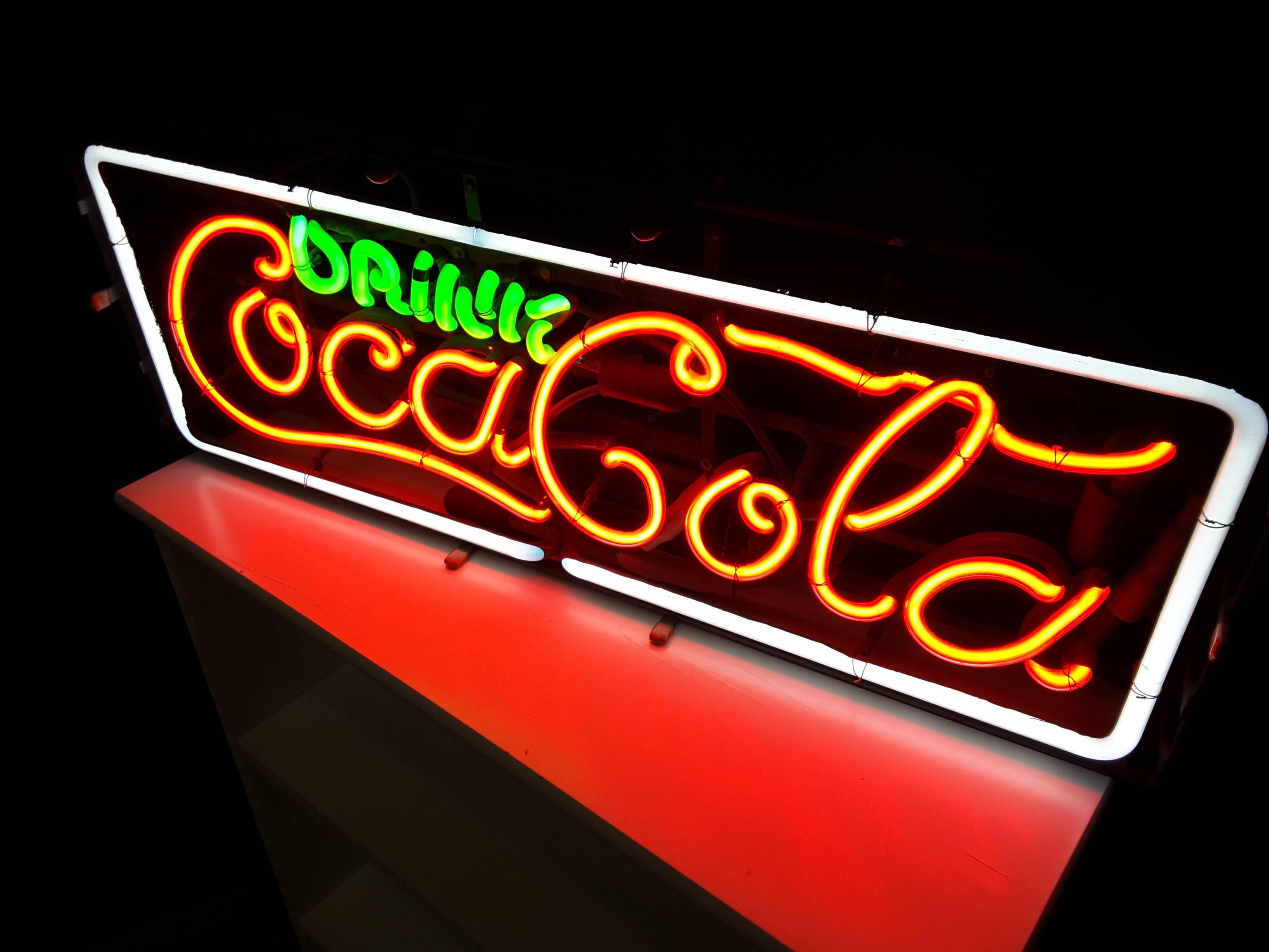 A great Drink Coca Cola 1960's three color neon sign, done in white, red and green Neon. The neon sign has been professionally restored, new ballast, and recharged neon gas. The sign has original front rubber bumper mounts, frame and tubes. The neon
