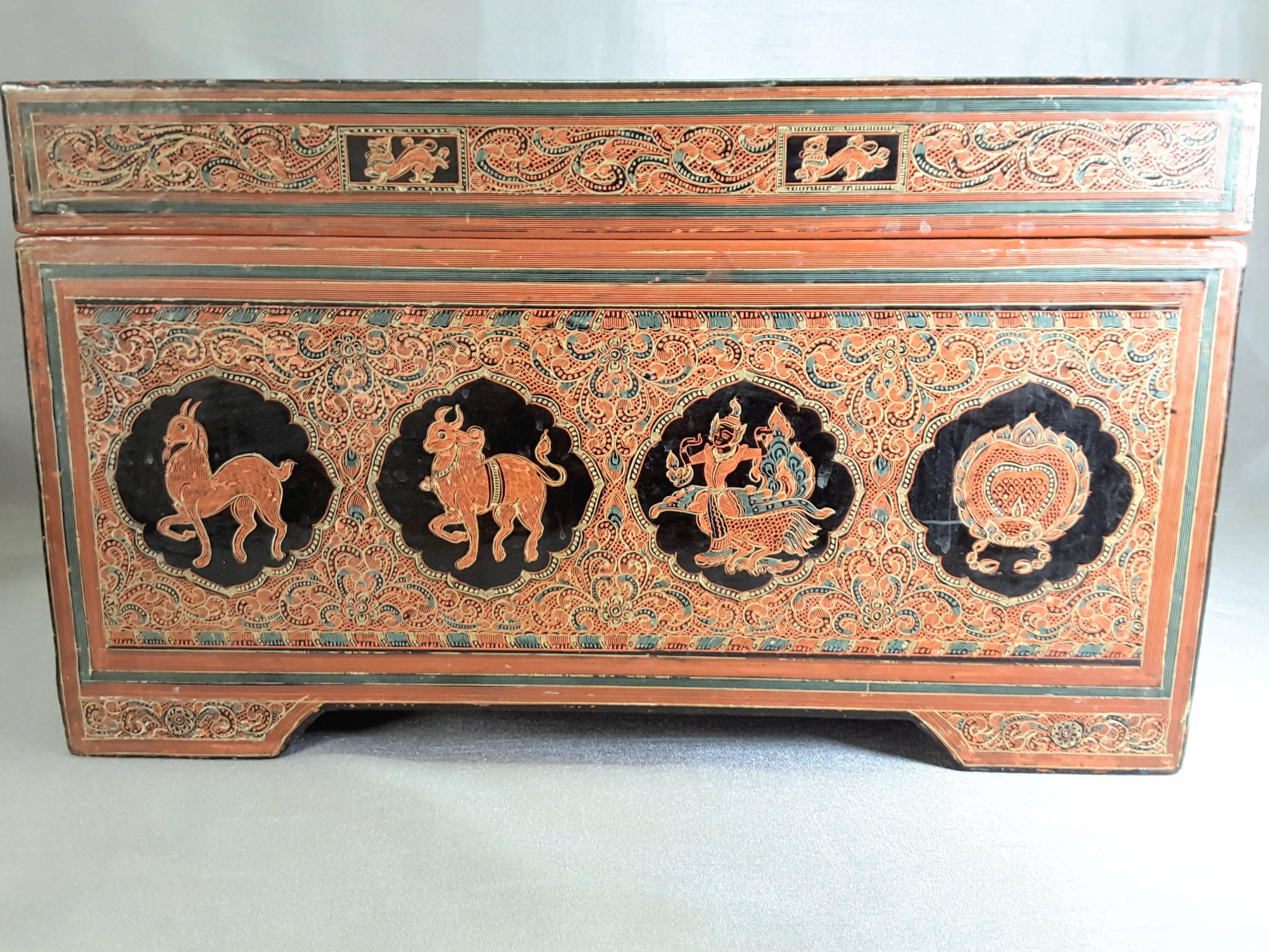 South East Asian document/storage box, Thailand or Burma, circa 1940s, decorated with figures and animals, done in an embossed style in black and browns, on a raised base. The lid is hinged and the interior in a single color. The document/storage