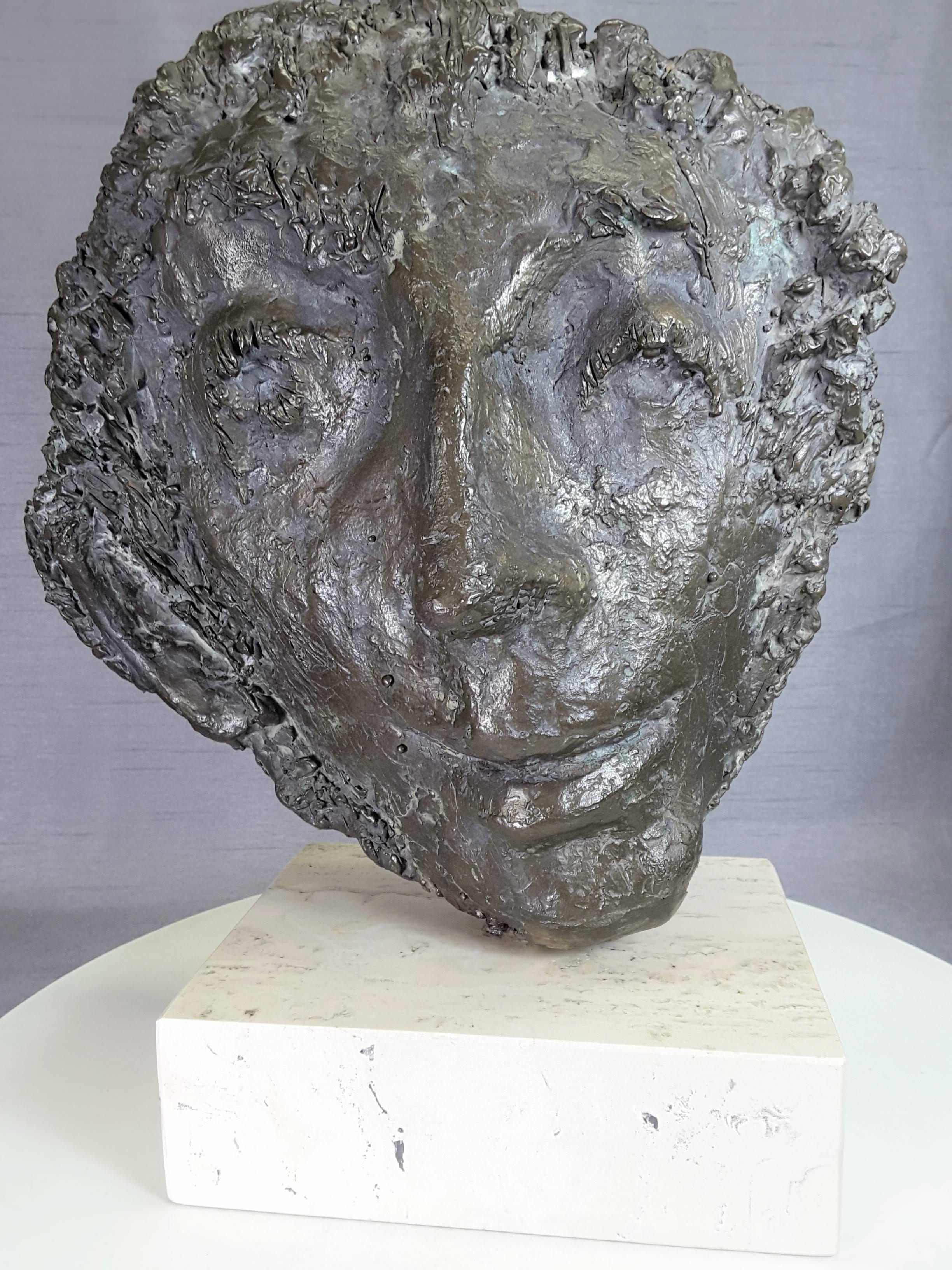 A large face bronze sculpture by Almuth Lutkenhaus (1930-1996), modern style face figure, mounted on a white marble square base. Very modern in style face with hair showing around the face. The head/face measures 15"-inches high x 12