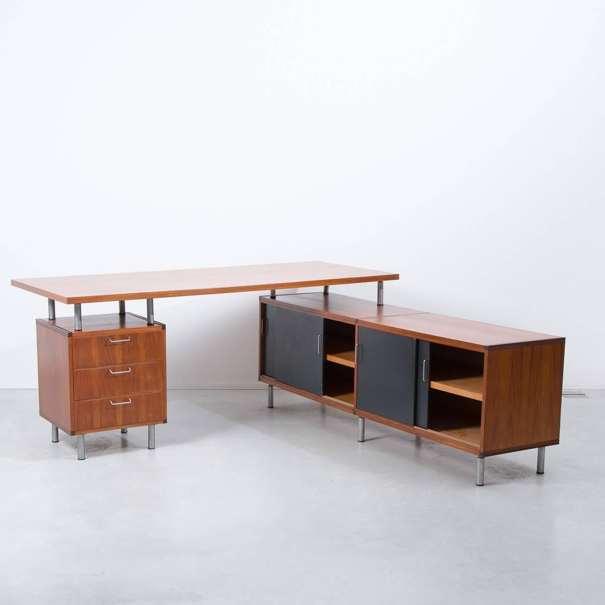 Large teak executive’s desk in an L-shape with useful cabinet with black laminate doors. Designed by Cees Braakman for his modular custom built series for Pastoe, Netherlands. Shows his signature curved birch ply drawers inside.

Great refinished