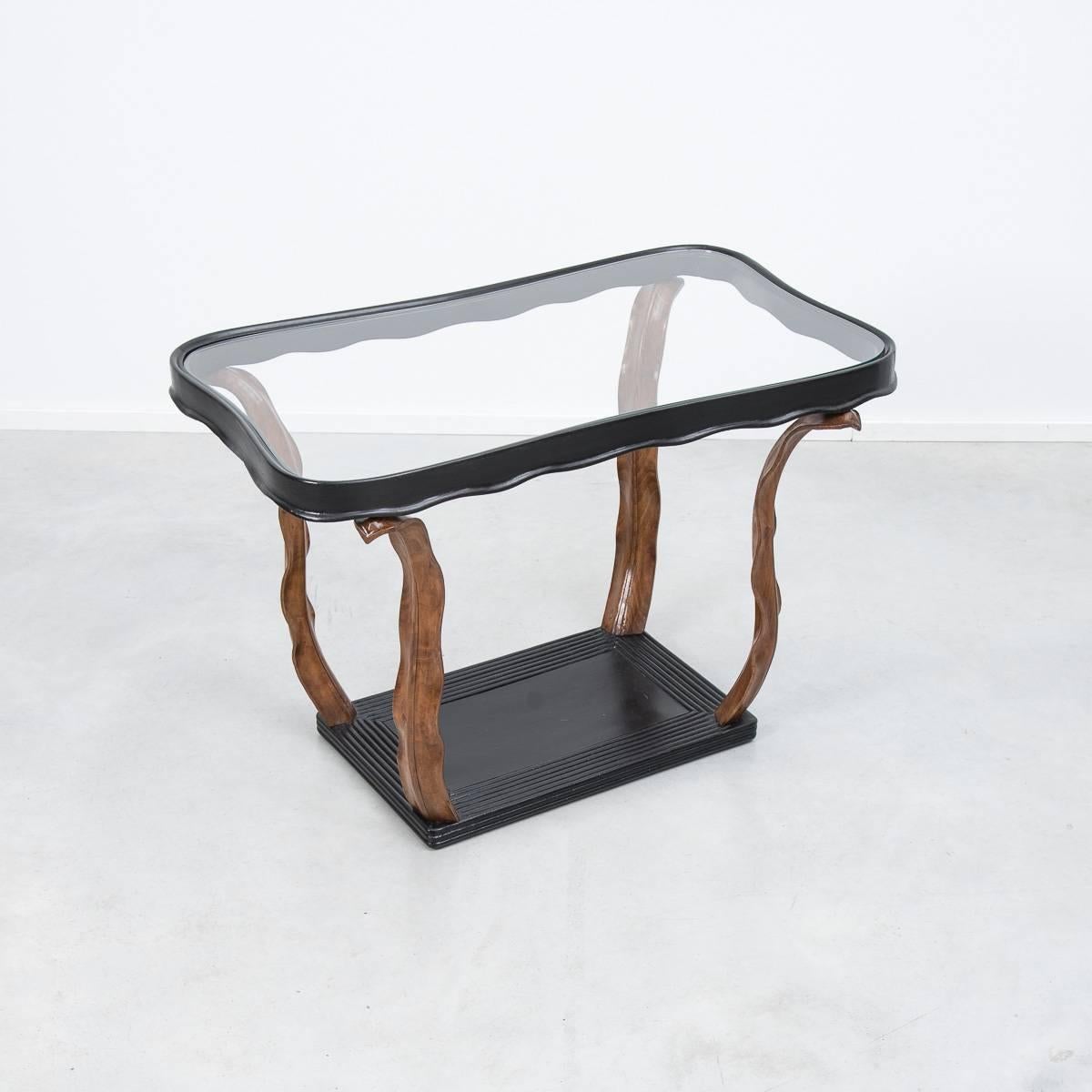 A refined side or coffee table designed by Milanese architect Paolo Buffa. The glass top is supported by a kidney shaped wood frame, which stands on four hand-carved wooden leaves. An exceptional piece of craftsmanship in the 1940s decorative