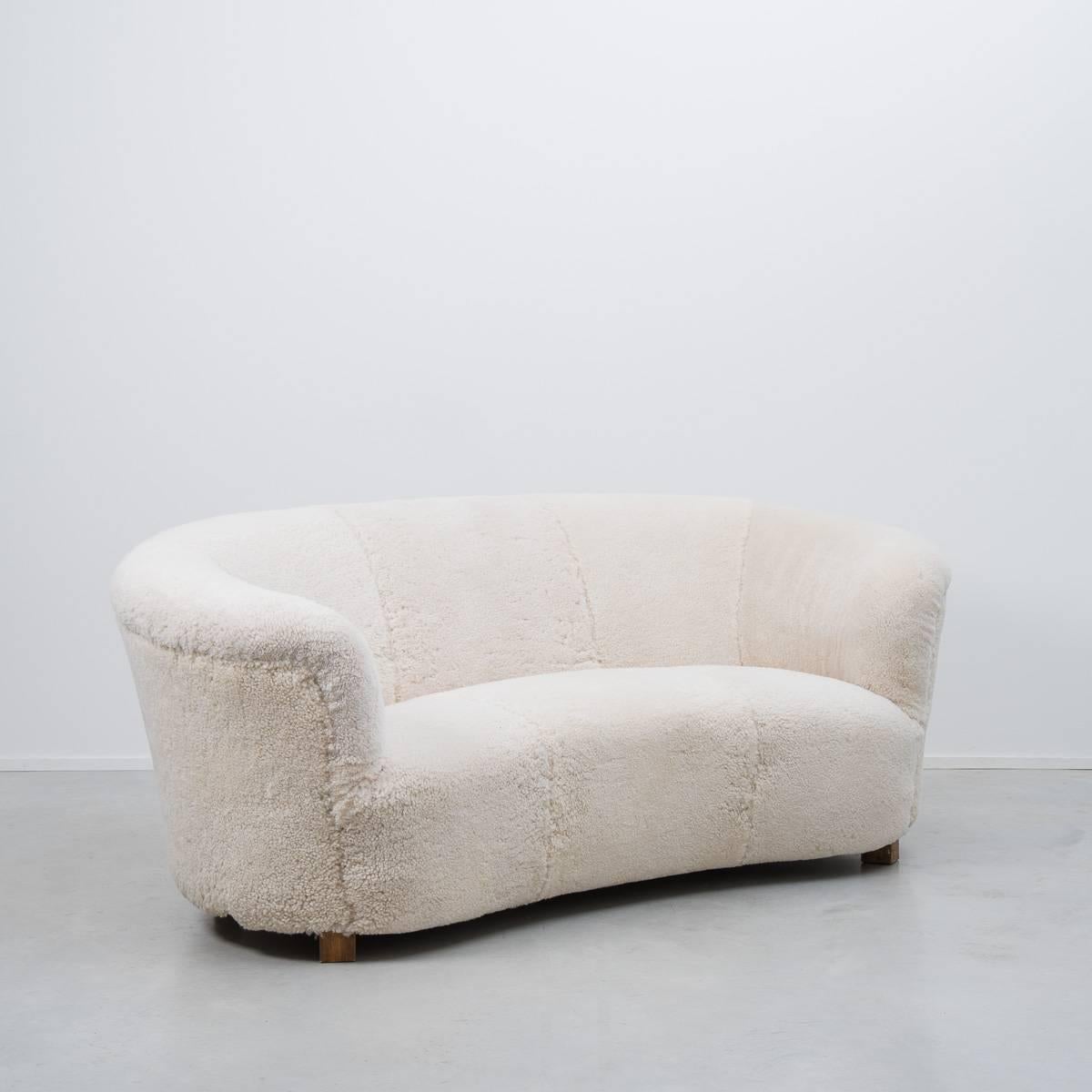 Early 1940s Danish Banana sofa in the manner of architect Flemming Lassen, newly reupholstered in genuine lambs wool. The sofa is of excellent craftsmanship, made by Slagelse Møbelværk, Denmark using proper materials – solid beech, metal springs,