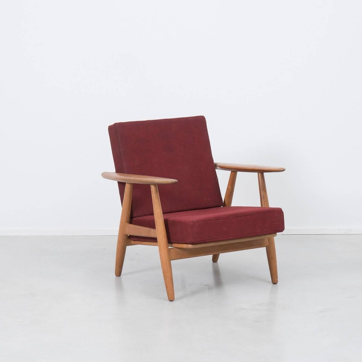 The cigar armchair in oak with loose cushions. The armchair was designed by Hans J. Wegner (1917-2007) in 1954 for GETAMA, Denmark. The chair is model GE 240 but is better known as The Cigar (cigaren). Extremely comfortable original sprung