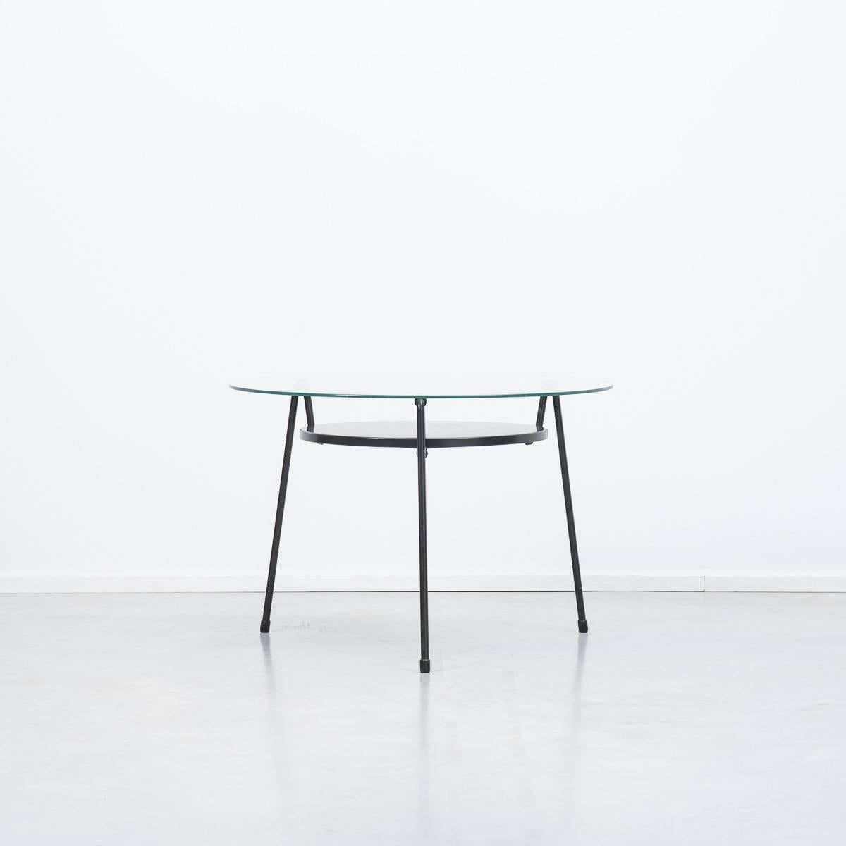 The ‘Mug’ coffee table, translating as ‘Mosquito’ was designed by Wim Rietveld, son of the famous Bauhaus designer, Gerrit Rietveld. Great example of Dutch Industrial design.

Black metal shelf, black frame, original glass top.