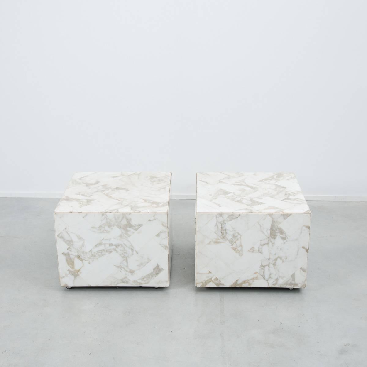 This handsome pair of marble tables on small caster wheels would make great display plinths for prized objects or an elegant set of side or bedside tables. The surfaces of the tables are created using a chic rectangular marble tile applied in a