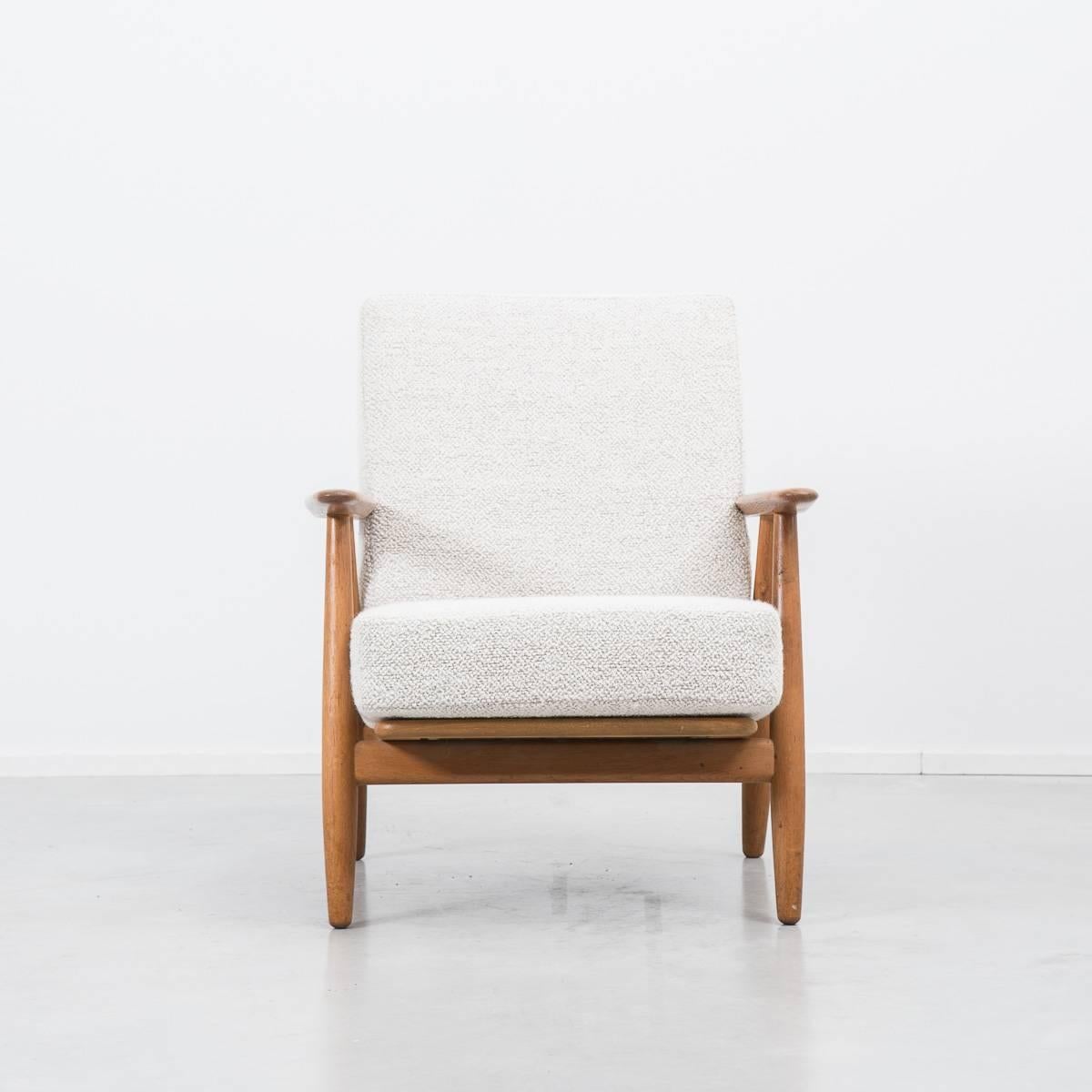 This Danish armchair in oak was designed by Hans J Wegner (1917-2007) in 1955 for GETAMA. Wegner is considered a pioneering furniture designer and master cabinetmaker and had a prolific output of seating during his working life. This chair is model