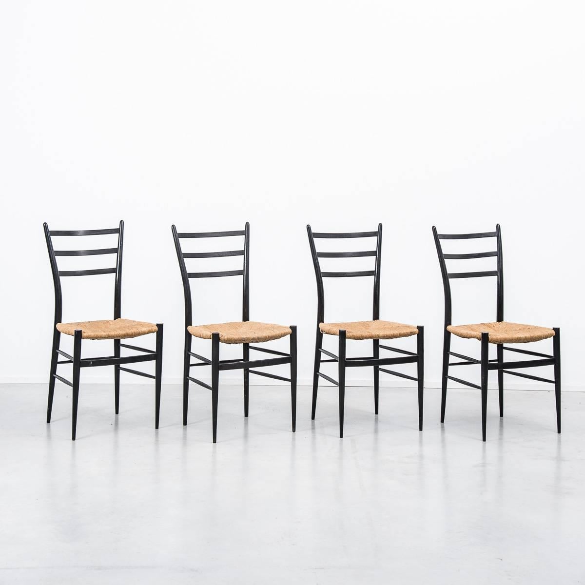 This set of elegant Spinetto chairs have a very thin profile with black ebonised frames and wicker seats, manufactured in the 1950s by Chiavari, Italy. These chairs were the inspiration for Gio Ponti’s famous Superleggera chair. 

          