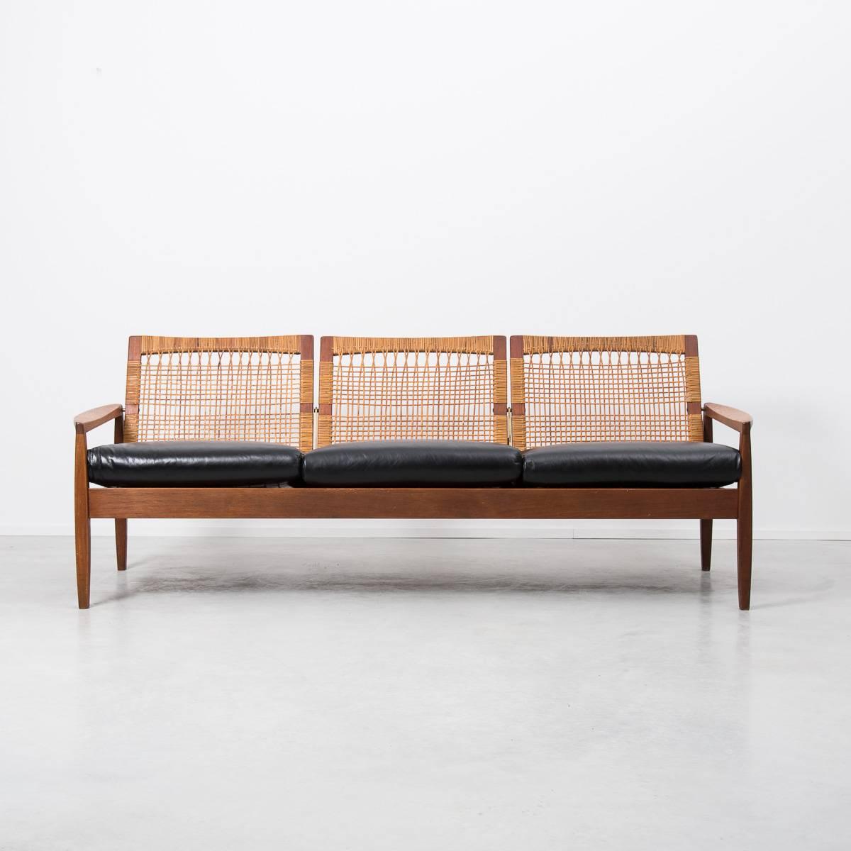 A rare and elegant teak framed and rattan backed three-seat sofa by one of Denmark’s leading furniture designers for Juul Kristensen, Denmark 1950s. Remarkably both the frame and woven rattan back are in excellent untouched original condition. The