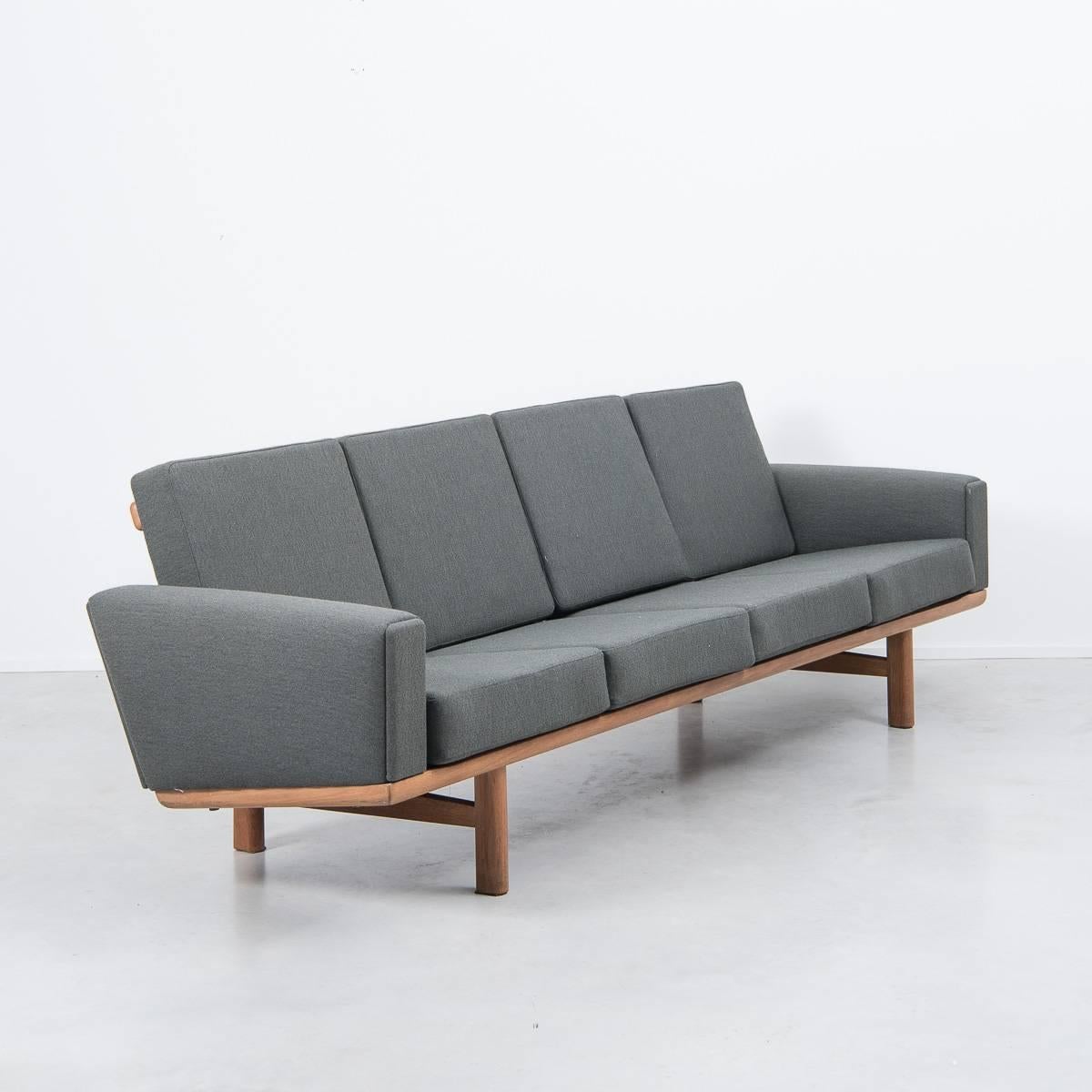 Four-seat solid teak sofa in dark grey-green De Ploeg Wool. Designed by the master craftsman of Danish modern seating, Hans J Wegner for GETAMA, Denmark in 1955. Newly reupholstered original sprung cushions with removable covers. Solid oak frame