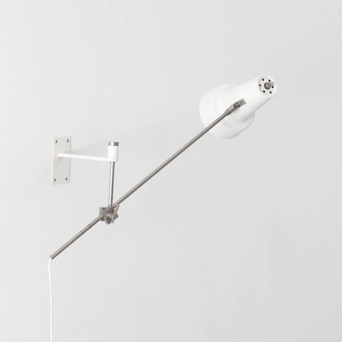 A model 55 white wall lamp with a nickel mechanism and articulated hood. Designed by one of the more obscure yet no less talented Dutch lighting designers of the era, Willem Hagoort. Unusually the lamp is hung beneath the bracket. 

The paintwork