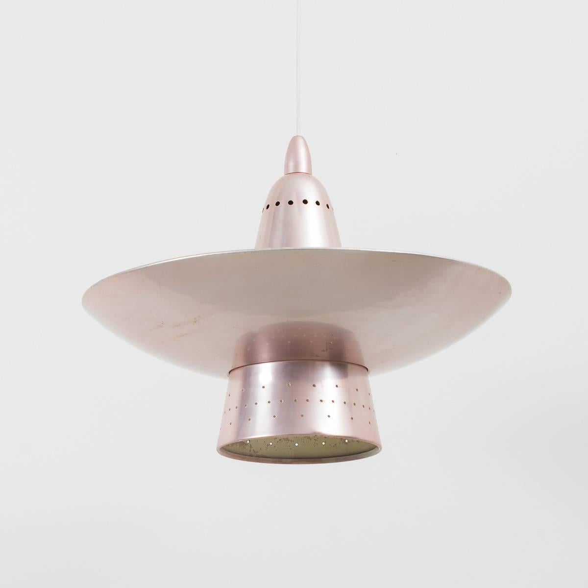 This fabulous pink anodized pendant was reclaimed from St. Thomas’ hospital (London) when it was refurbished years ago. The shade sits over the conical body of the lamp which has sections cut into it so that the light emits up as well as down. The