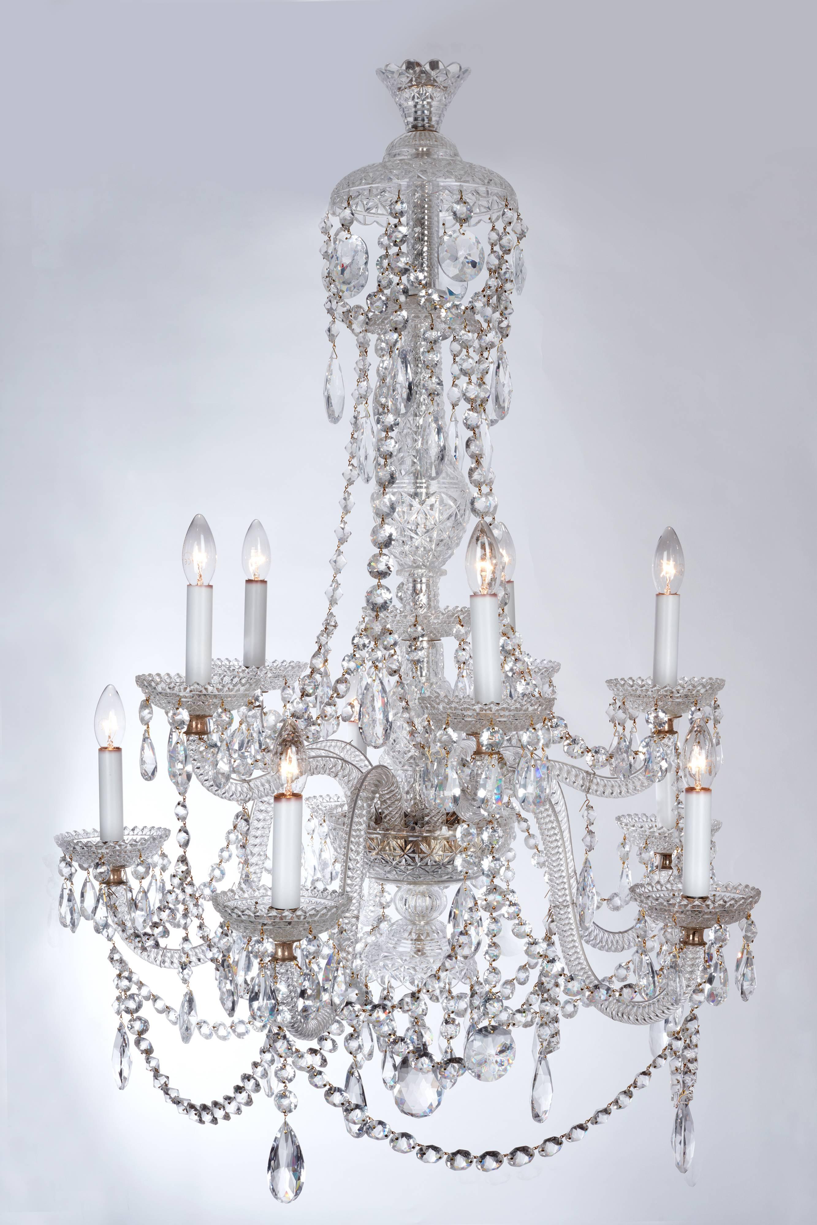 A large pair of fine English clear crystal glass chandeliers. Exquisitely executed with rope twist arms terminating in crisply cut circular dishes. With finely cut circular buttons terminating with clear glass crystal pear drops. With the central