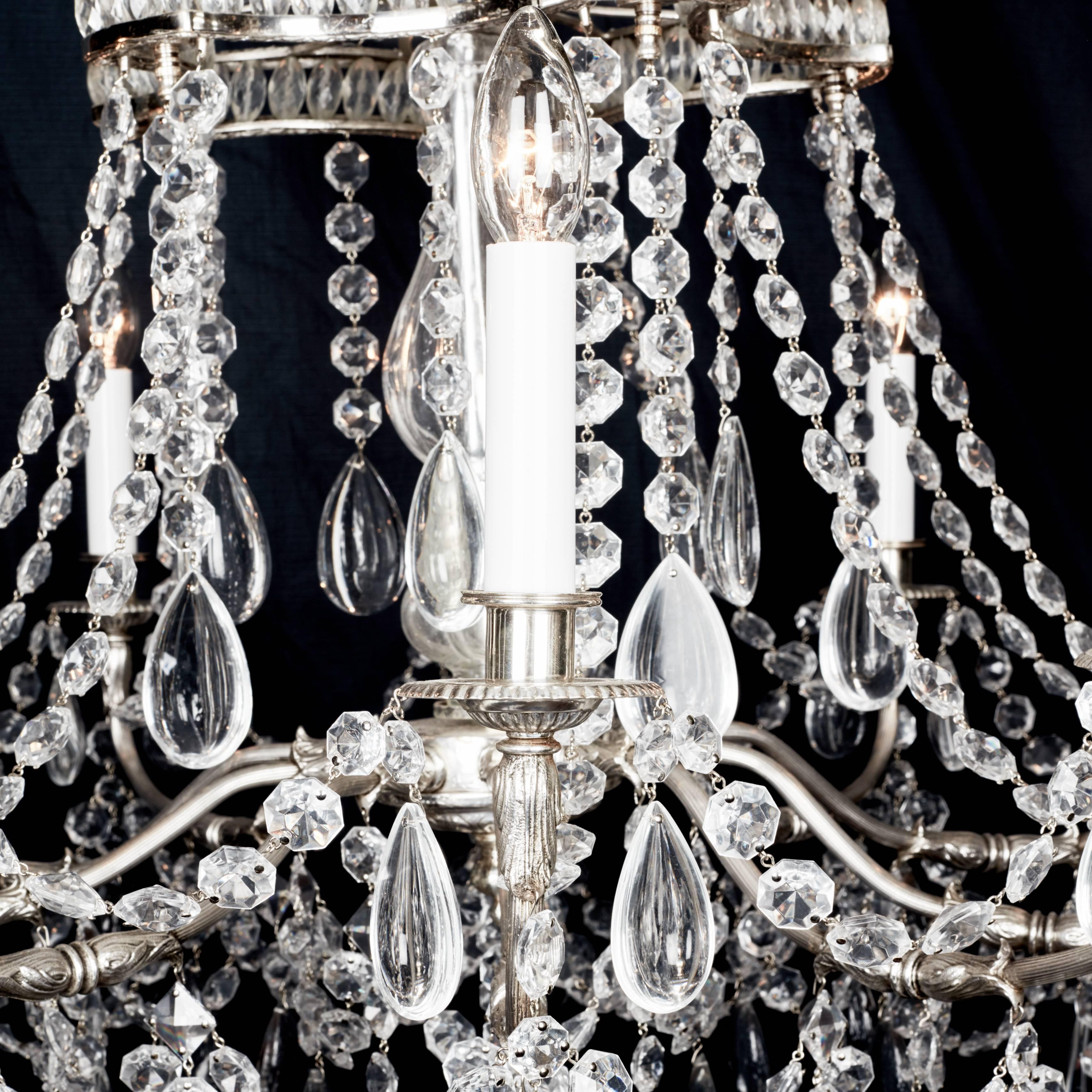 A Versailles Louis XVI style French chandelier
Silver ten-armed chandelier with outswept arms terminating in candle lights supported by chains and supporting a gallery hooped and separated by lozenge hand cut beads and hung on the lower section of