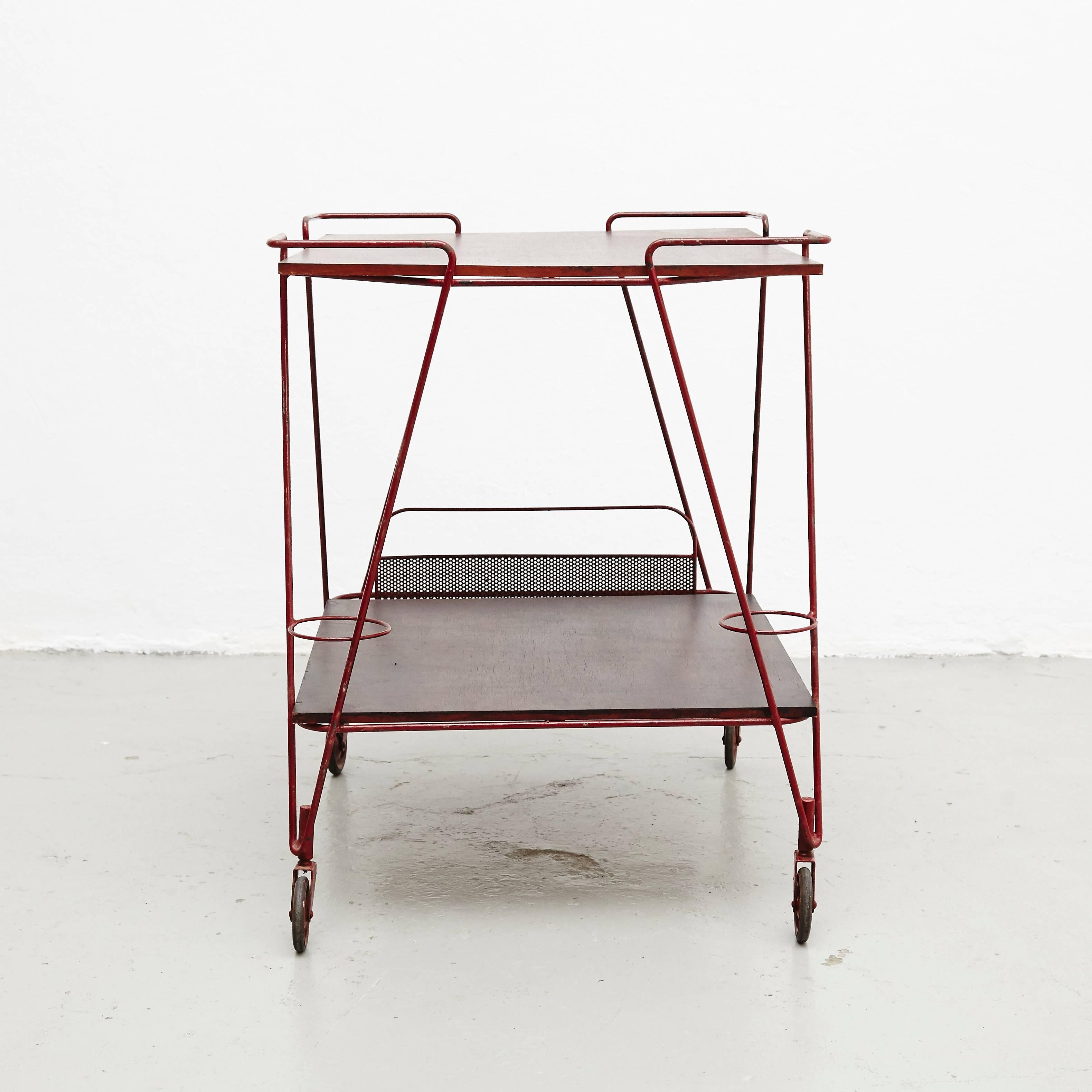 Trolley designed by Mathieu Matégot.
Manufactured by Ateliers Matégot (France), circa 1950.
Perforated metal lacquered in red and laminated wood.

In good original condition, with minor wear consistent with age and use, preserving a beautiful