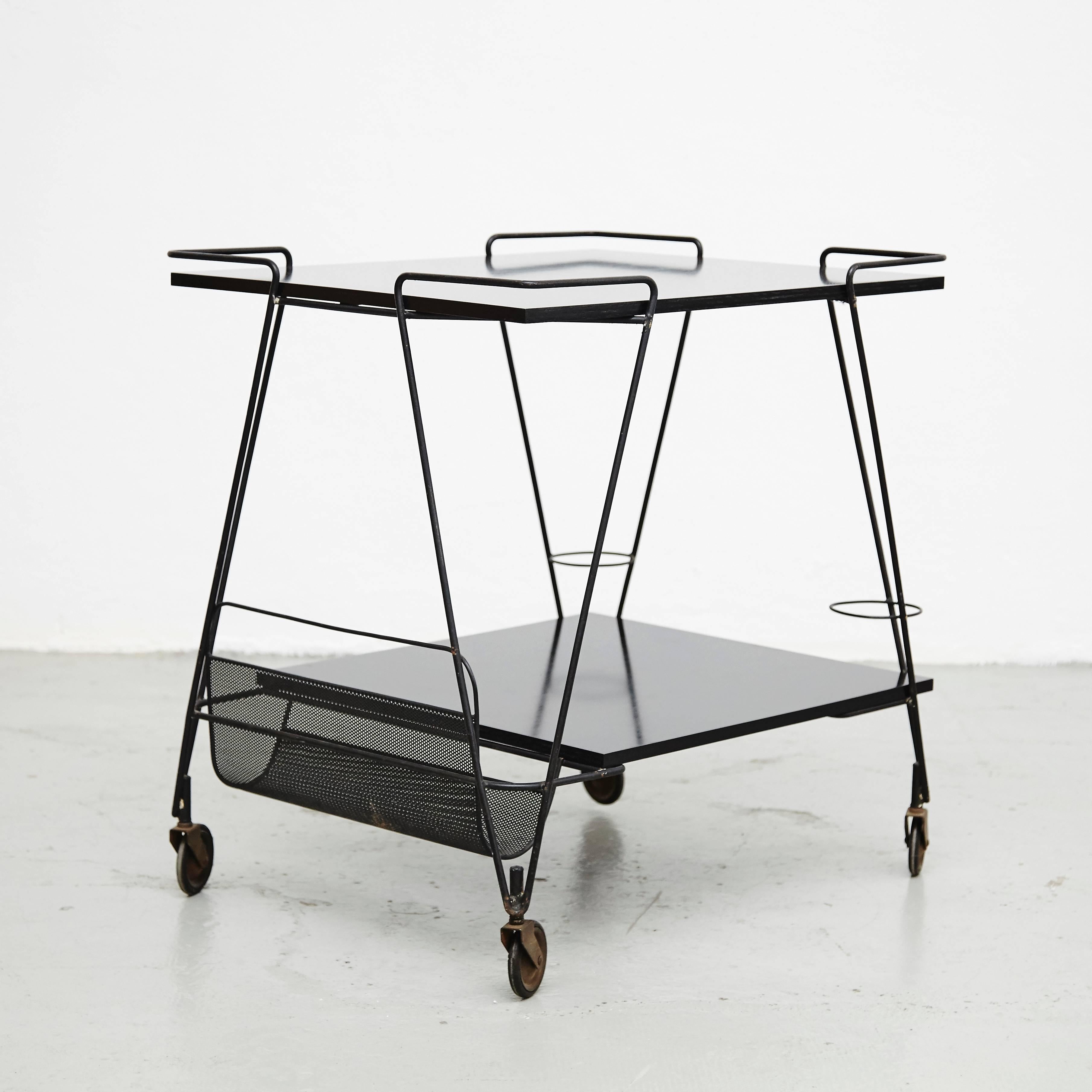 Trolley designed by Mathieu Matégot.
Manufactured by Ateliers Matégot (France), circa 1950.
Perforated metal lacquered in black and laminated wood.

In good original condition, with minor wear consistent with age and use, preserving a beautiful