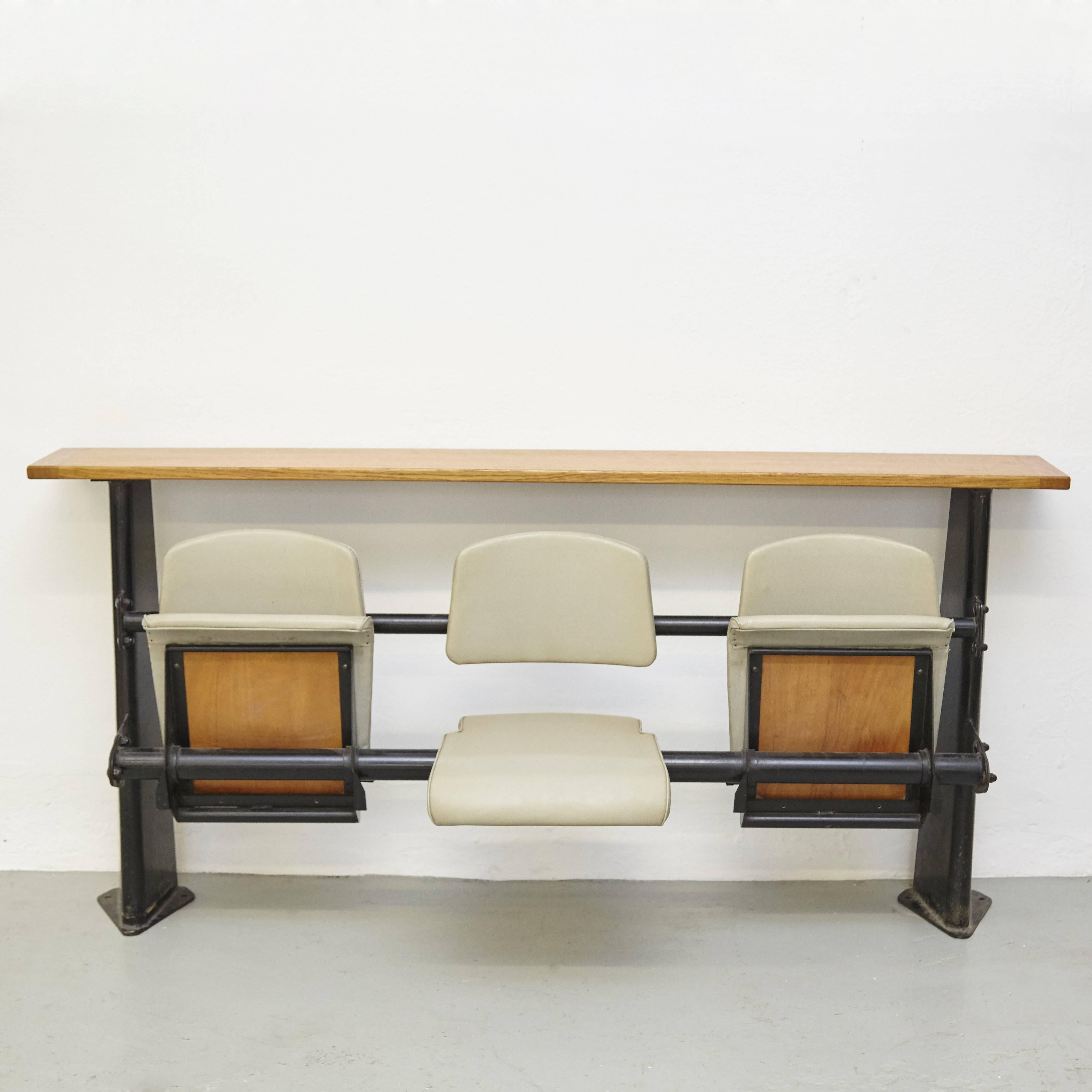 Bench designed by Jean Prouve, circa 1950.

Black lacquered steel sheet structure supports three standard seats with light grey faux leather upholstery.

In good original condition, with minor wear consistent with age and use, preserving a