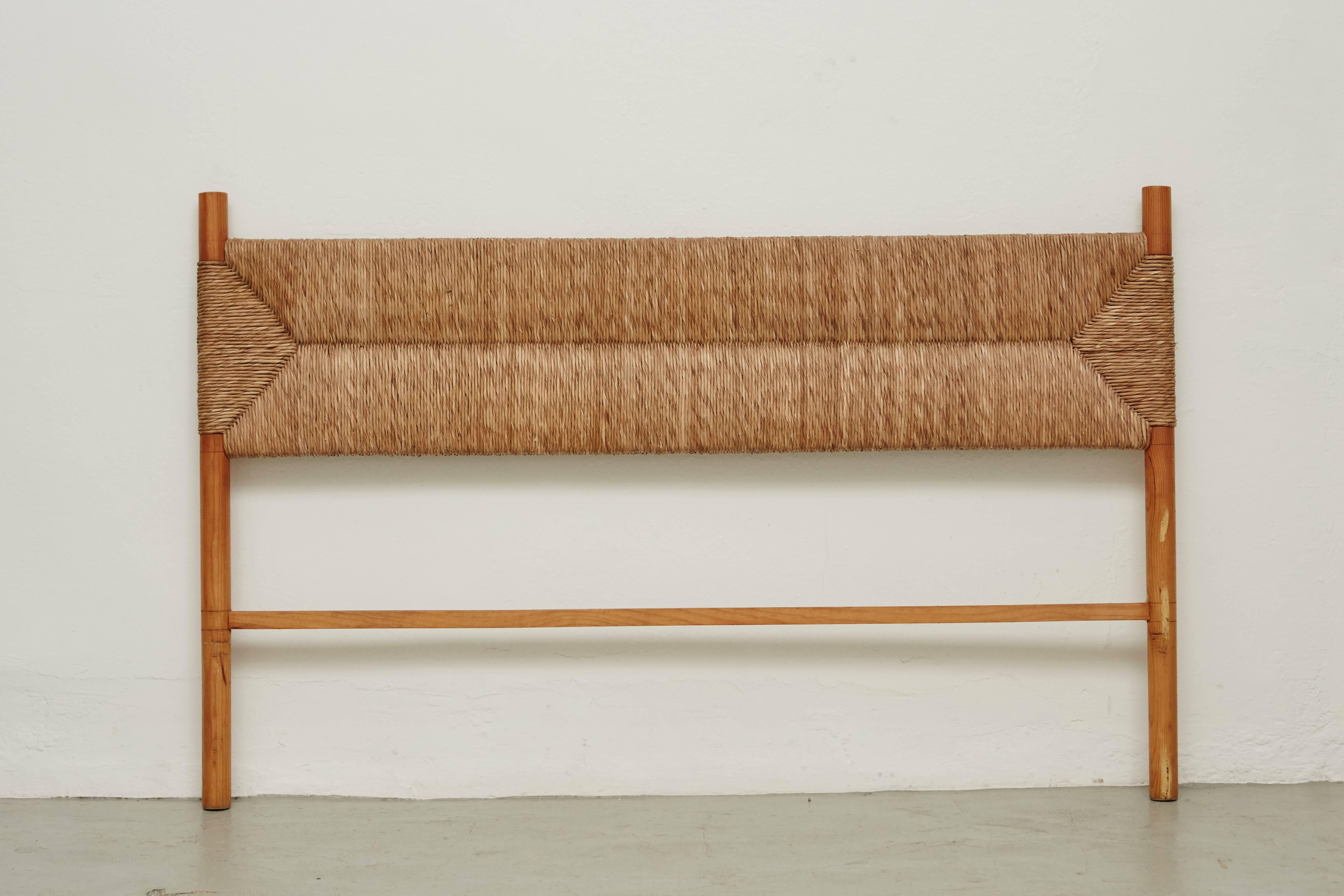 Headboard designed in the style of Charlotte Perriand, made by unknown manufacturer.

Wood and rattan.

In good original condition, with minor wear consistent with age and use, preserving a beautiful patina.

Charlotte Perriand (1903-1999) she