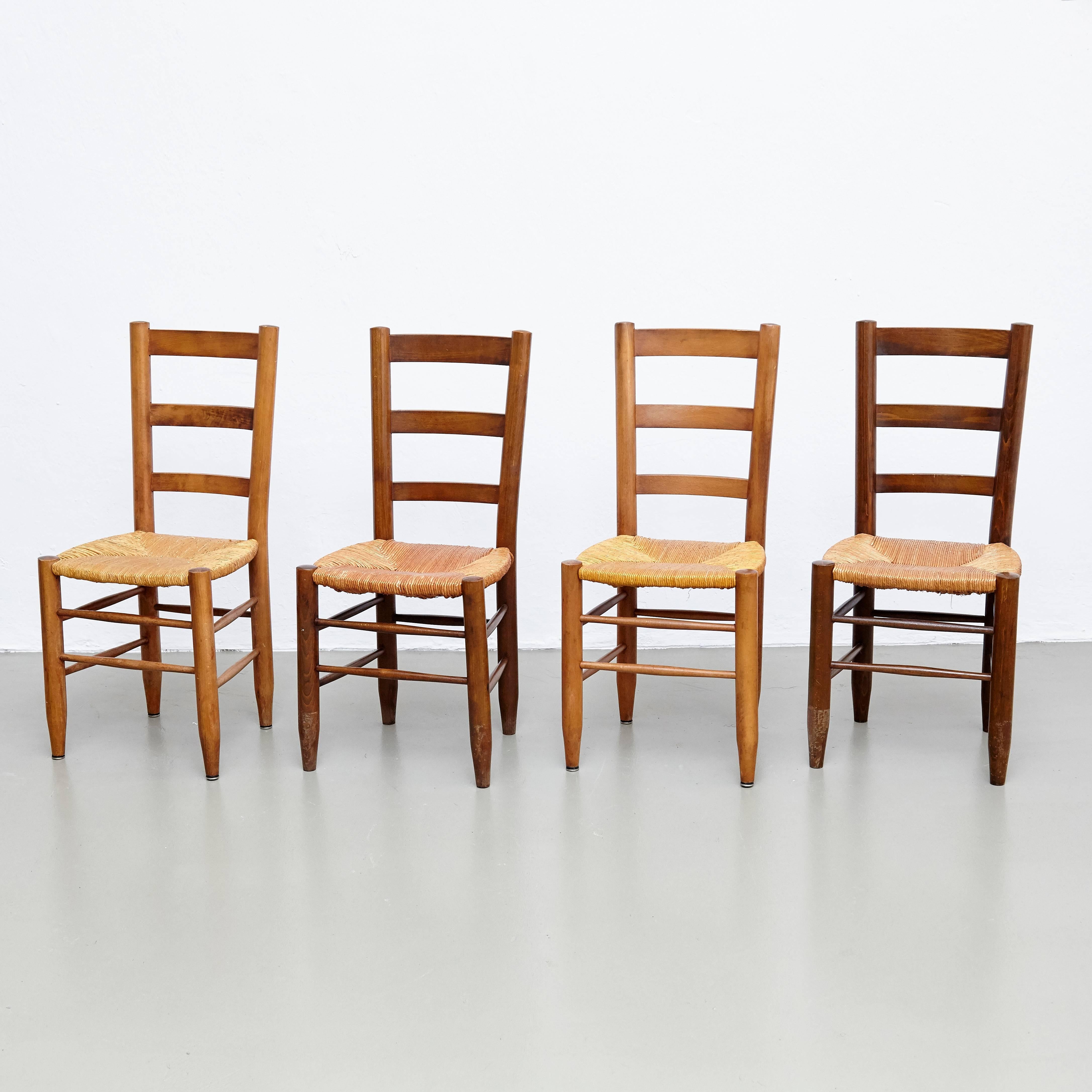 Set of eight dining chairs, model Meribel, designed by Charlotte Perriand, circa 1950.

Solid wood base and legs, and rush seat.

In good original condition, with minor wear consistent with age and use, preserving a beautiful patina. The seats