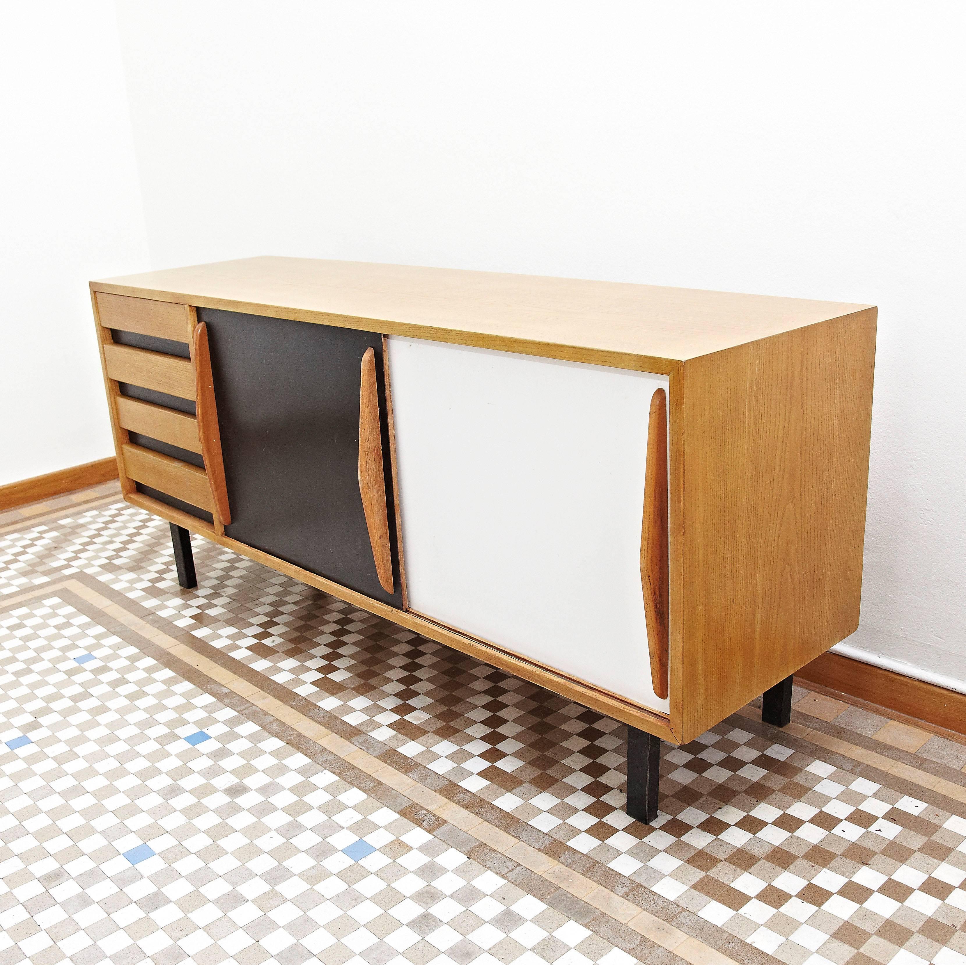 Sideboard designed by Charlotte Perriand, circa 1950.
Edited by Steph Simon (France).
Steel base, wood structure and grips, lacquered sliding doors.

Provenance: Cansado, Mauritania (Africa).

In good original condition, with minor wear