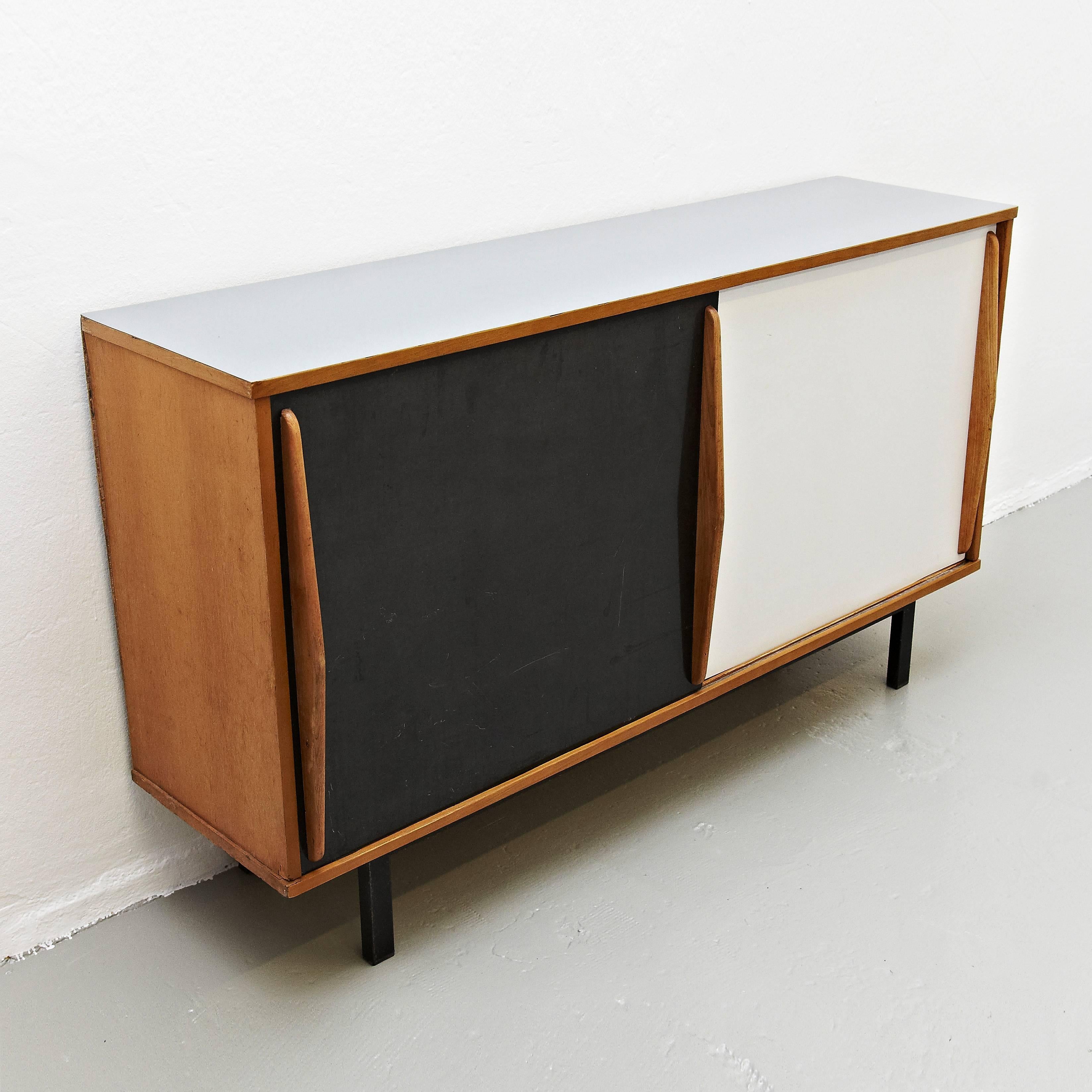 Sideboard designed by Charlotte Perriand, circa 1950.
Edited by Steph Simon (France)
Steel base,wood structure and grips, lacquered sliding doors.

Provenence: Cansado, Mauritania (Africa)

In original condition, with wear consistent with age