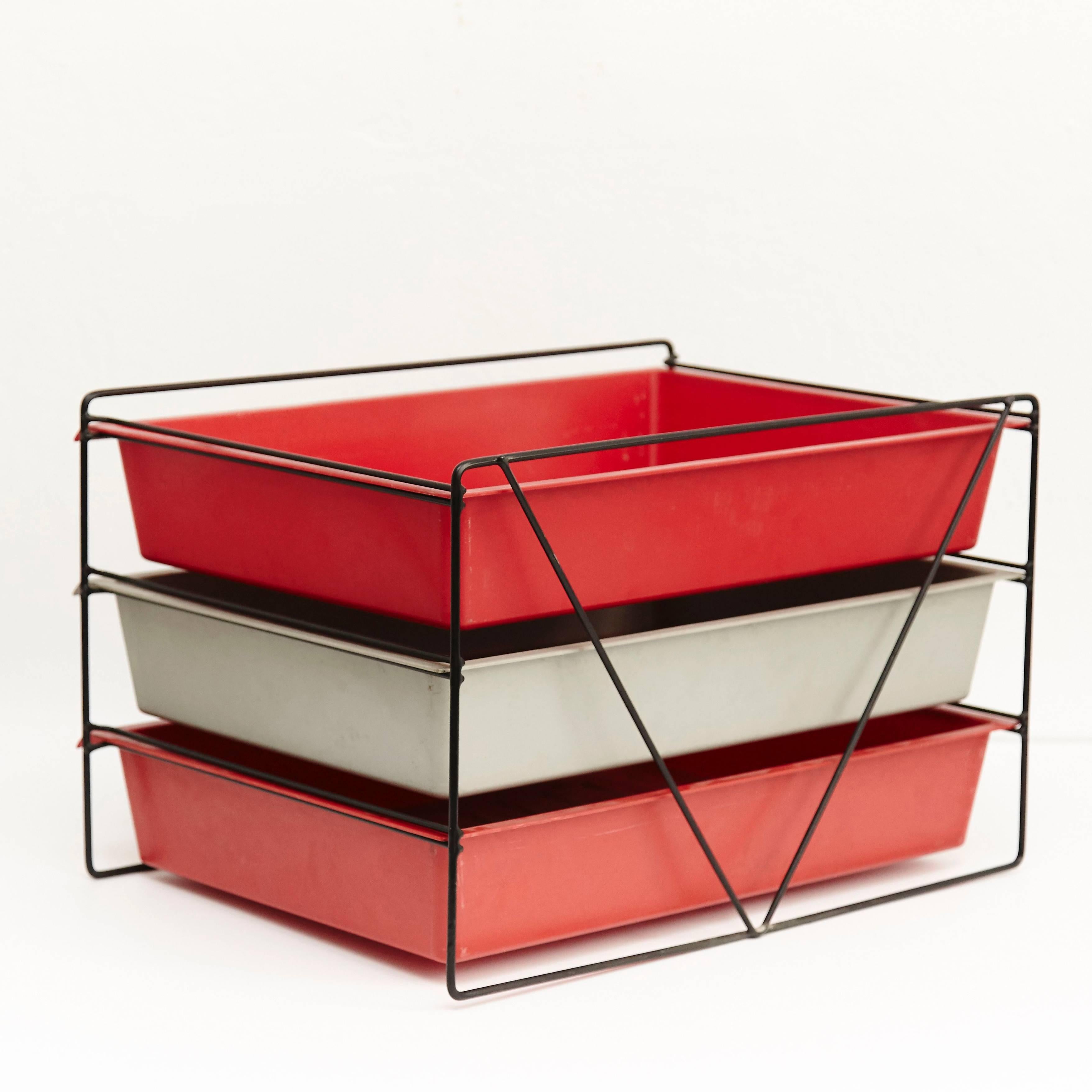 File rack designed by Charlotte Perriand, circa 1955.
Manufactured in France, circa 1955.
Moulded plastic and painted metal.

Each drawer moulded with Modele Charlotte Perriand/Brevete S.G.D.G.

In good original condition, with minor wear