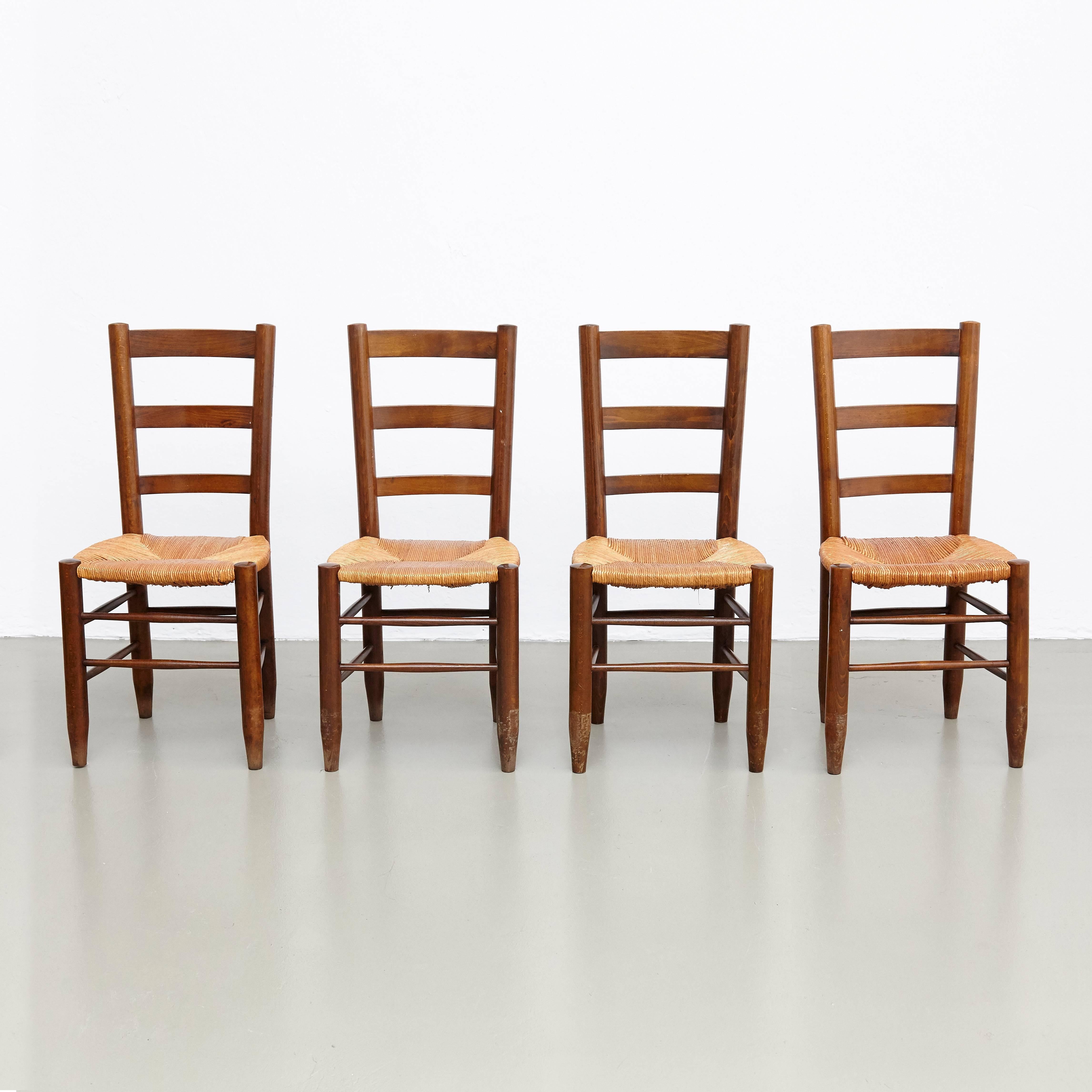 Set of four dining chairs, model no. 19, designed by Charlotte Perriand, circa 1950.

Solid wood base and legs, and rush seat.

In good original condition, with minor wear consistent with age and use, preserving a beautiful patina. The seats