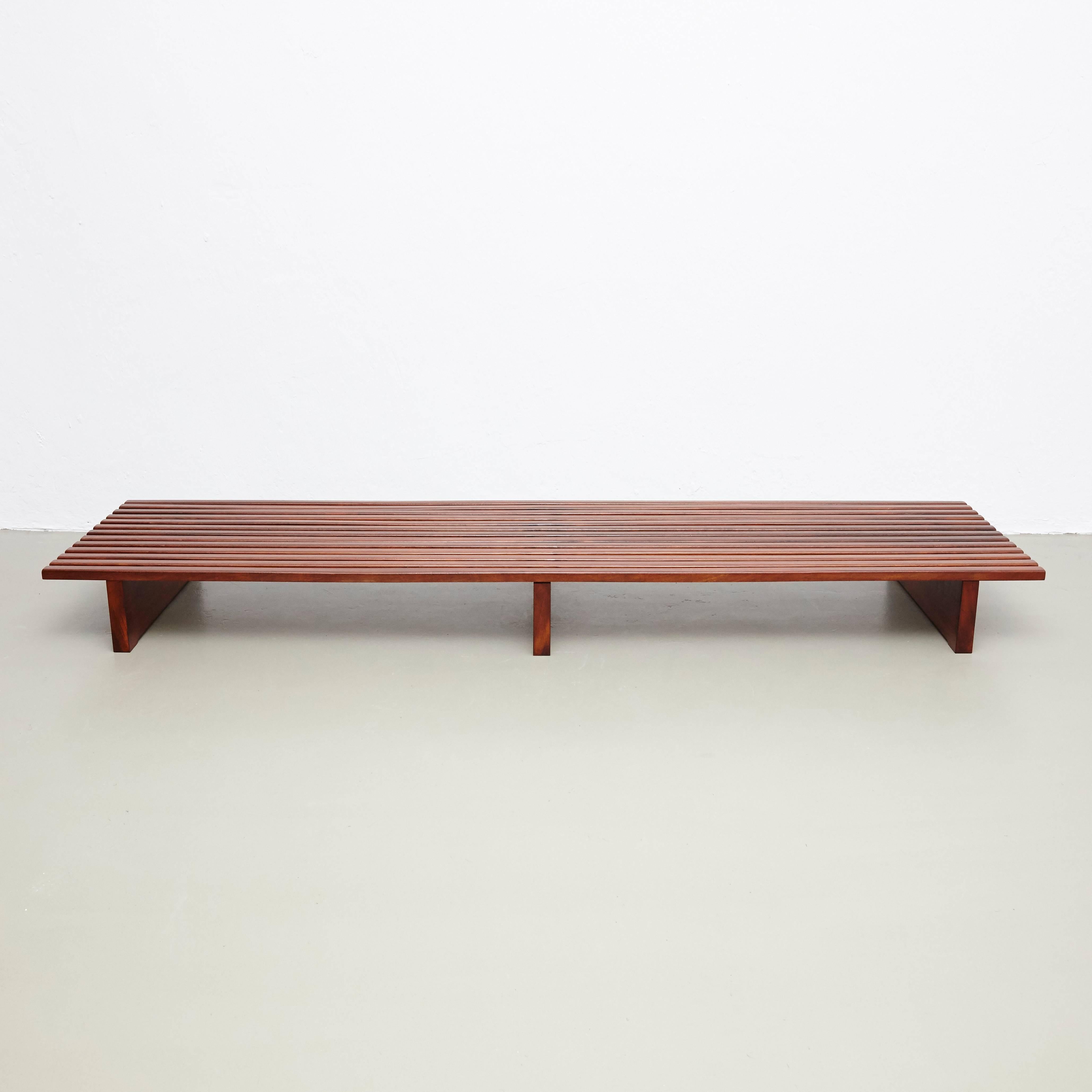 Bench designed by Charlotte Perriand, circa 1950.
This model is with 13 slats of wood.

Mahogany wood base and structure.

Wooden legs seems to be latter added by previous owner.

Provenance: Cansado, Mauritania (Africa).

In good original