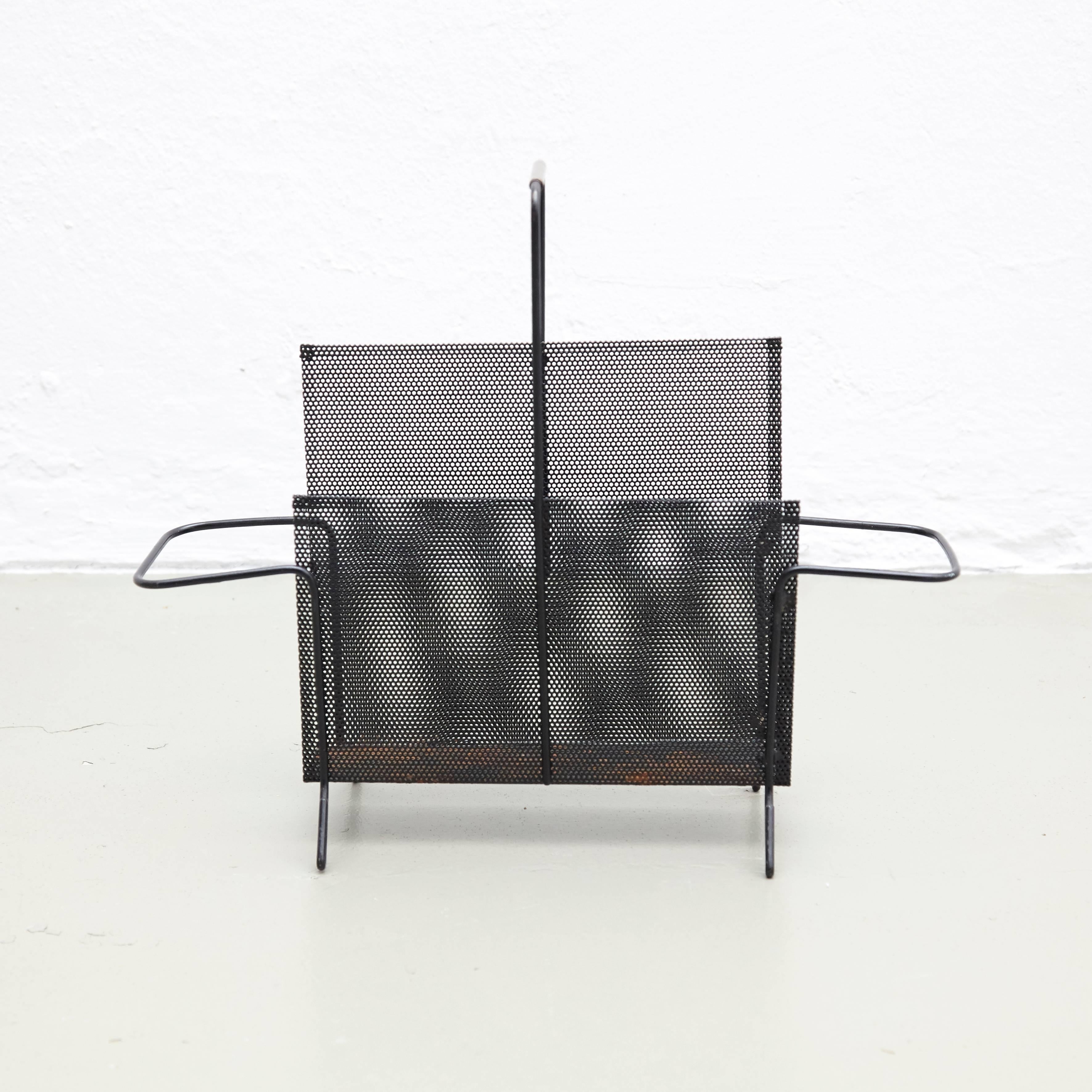 Magazine holder, designed by Mathieu Mategot.
Manufactured by ateliers Mategot (France), circa 1950.
Folded, perforated metal.

In good original condition, with minor wear consistent with age and use, preserving a beautiful patina. With some