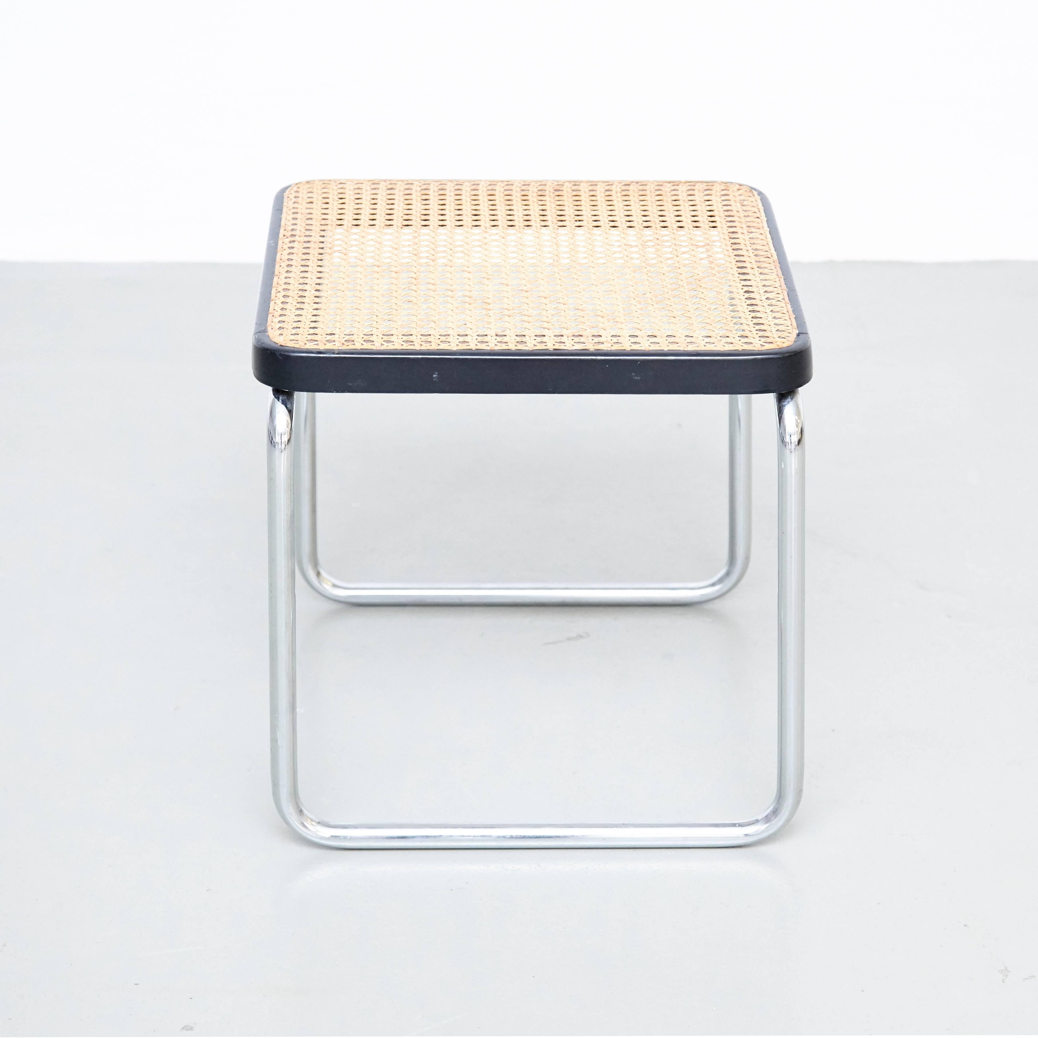 Hocker:: entworfen von Marcel Breuer 
Hergestellt von Thonet. 

Metallrohrgestell mit Holzstruktur und Rattan. 

In gutem Originalzustand:: mit geringen alters- und gebrauchsbedingten Gebrauchsspuren:: die eine schöne Patina erhalten haben. 

Marcel