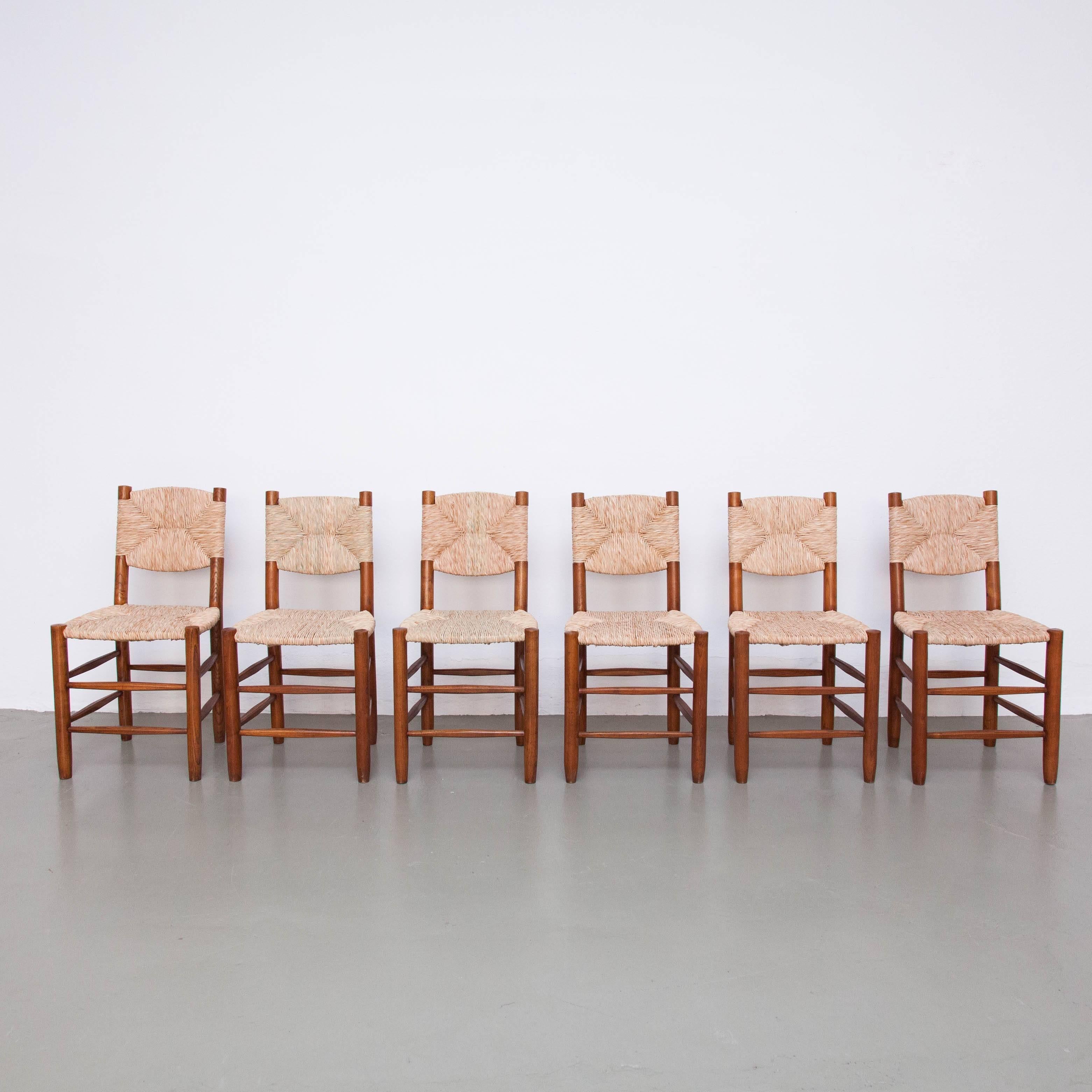 Set of six chairs designed by Charlotte Perriand, circa 1950.
Manufactured in France.

Chairs made in wood base and legs with rush seat.
Rush seats have been redone according to the original design.

In good original condition, with minor wear