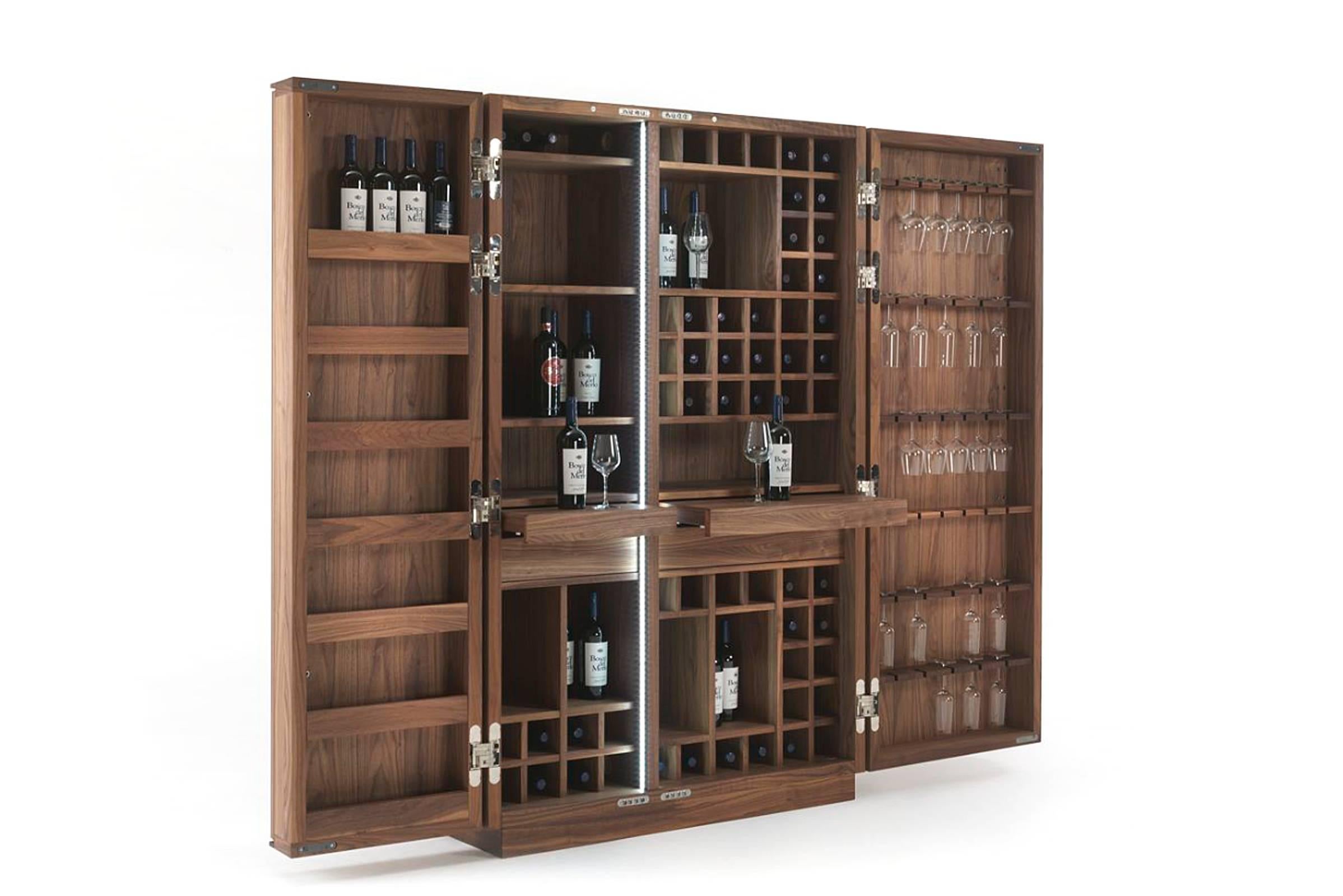 Cabinet wine storage in solid walnut wood.
Central storage unit with two Drawers and two pull-out
Shelves. Opening with push-pull system. Ten open
spaces divided by fixed shelves. Wooden grid with 
56 Bottles Rack. LED lights strips fitted onto the