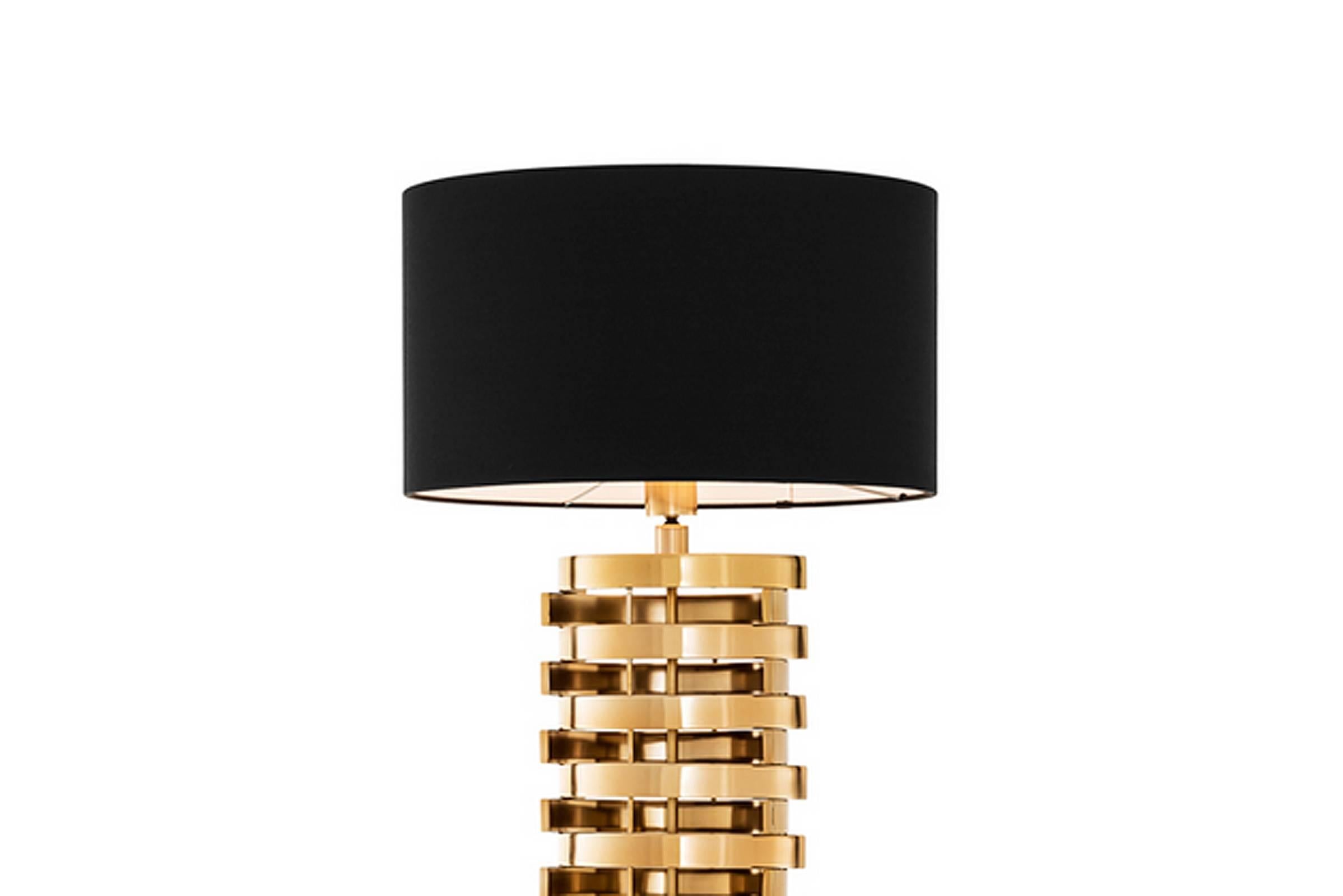 Floor lamp in gold finish with black lamp shade.
