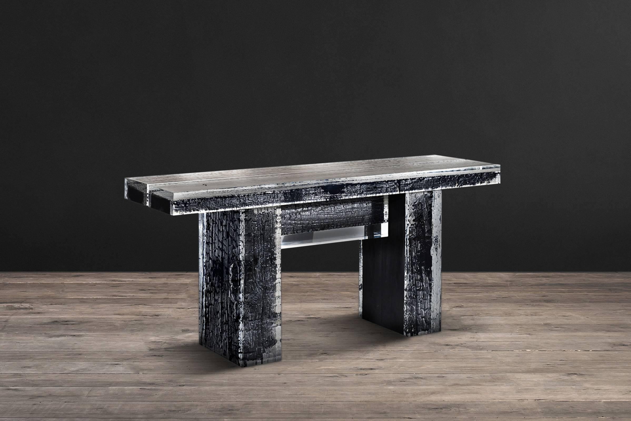 Console table Ice Burnt with burnt timber in crystalline 
acrylic. Ice-cold smooth appearance contrasts with 
Charred rugged timber. Table features four beams 
of timber encased in acrylic, set atop two large 
timbers also in acrylic. The